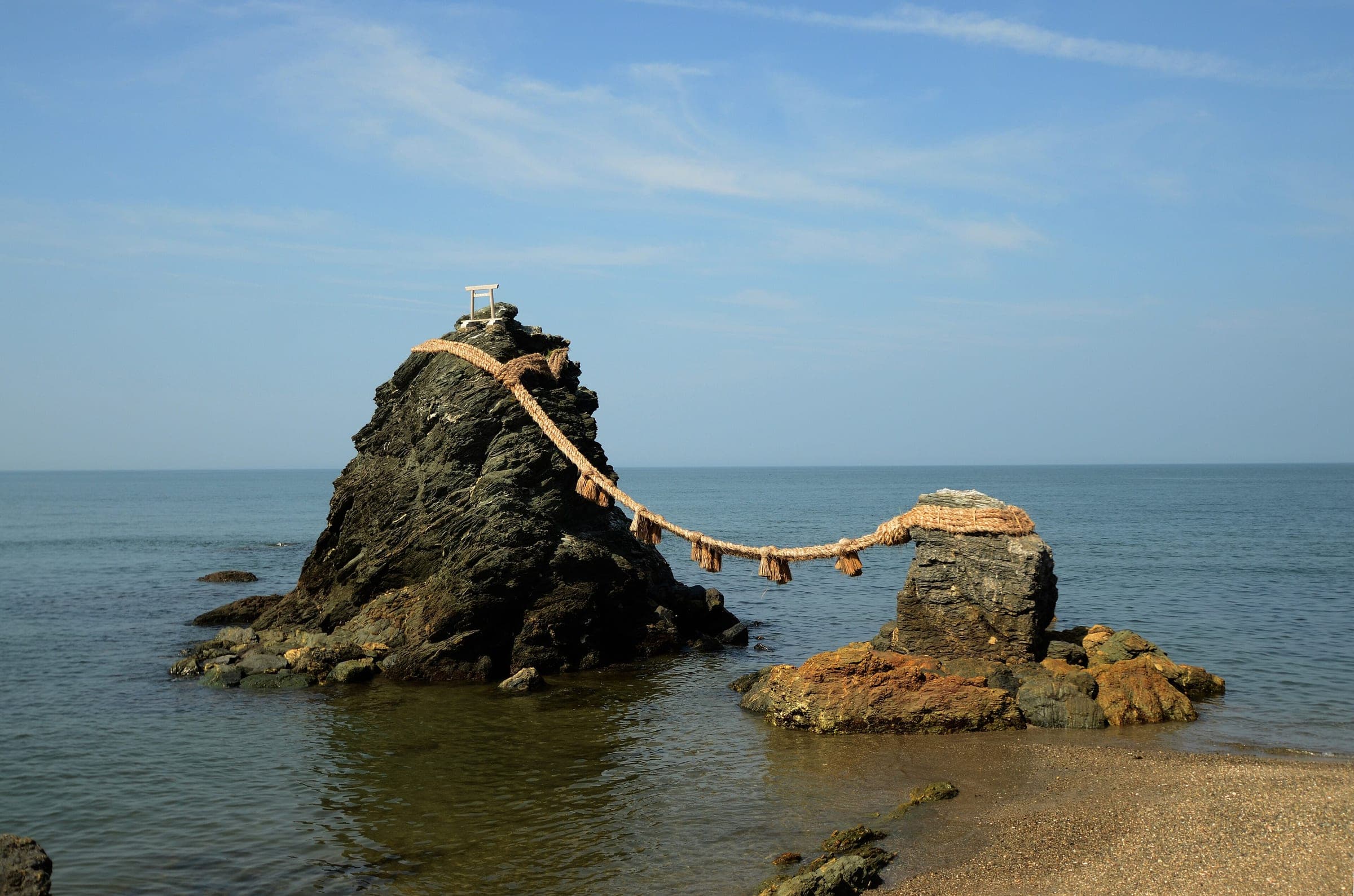 A thick straw rope joins the two Meoto Iwa rocks offshore at Futami in Ise