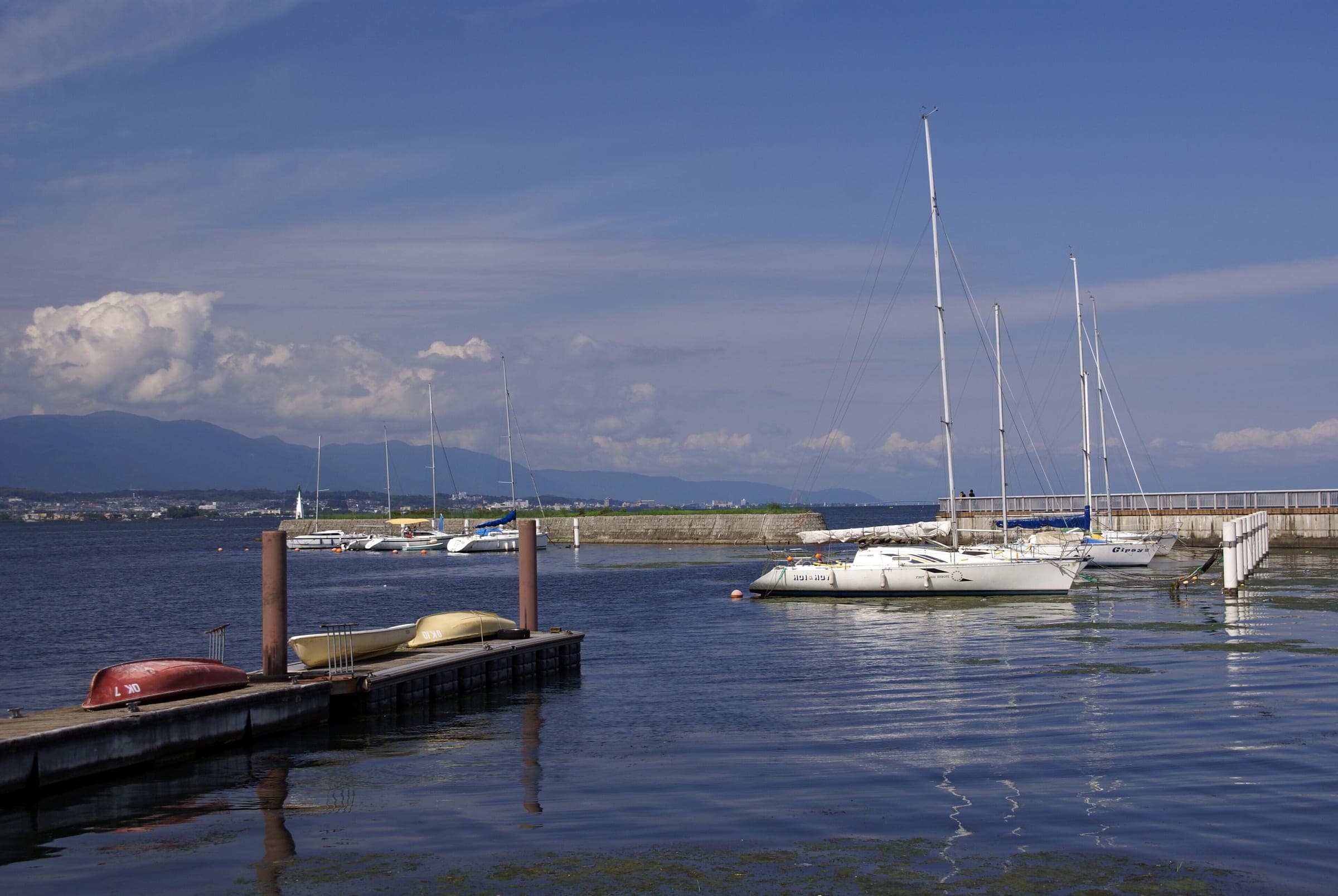 Yachts lie moored in Otsu port with the hills of the west shore across Lake Biwa
