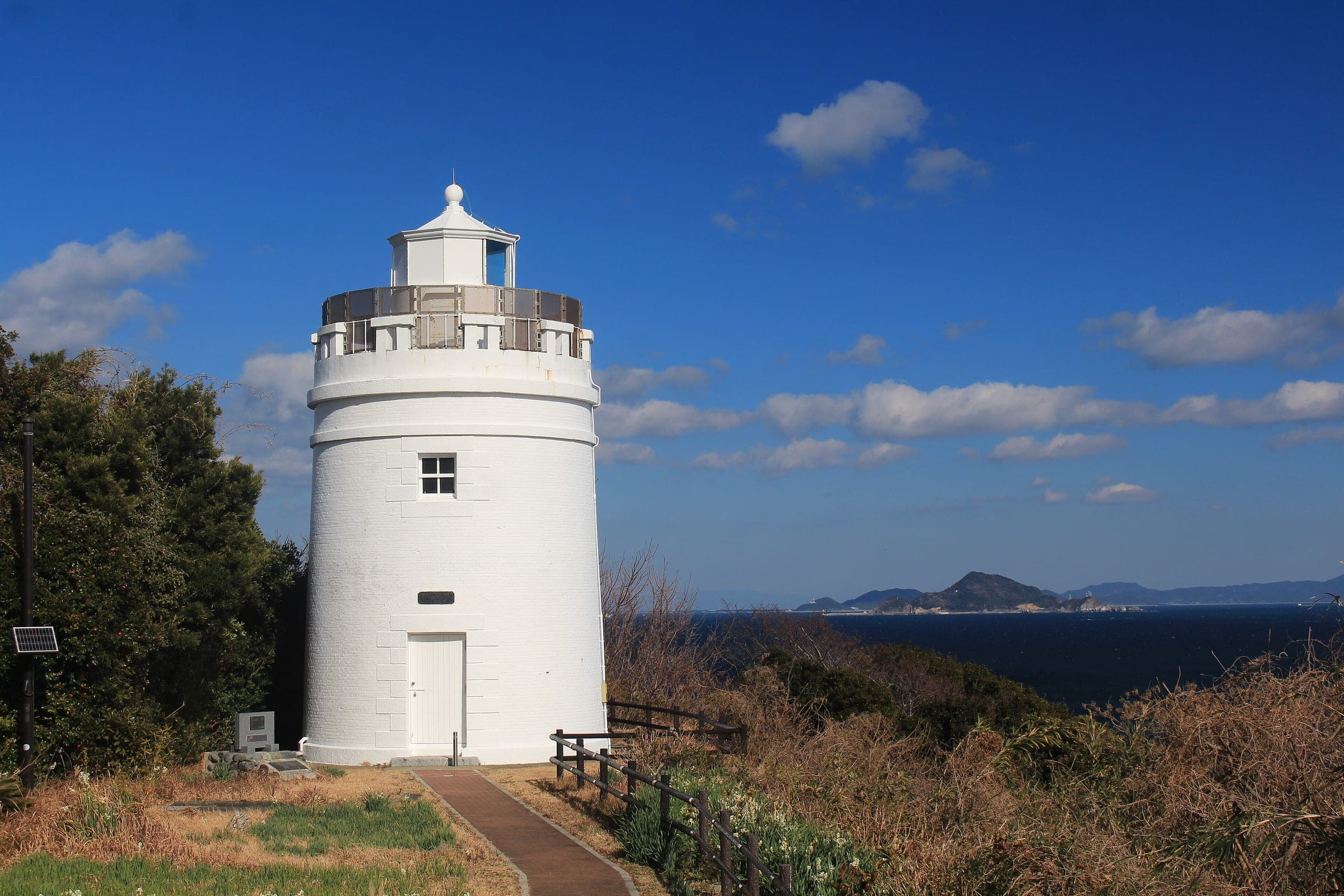 The white Sugashima Lighthouse stands above the sea on an island off Toba in January