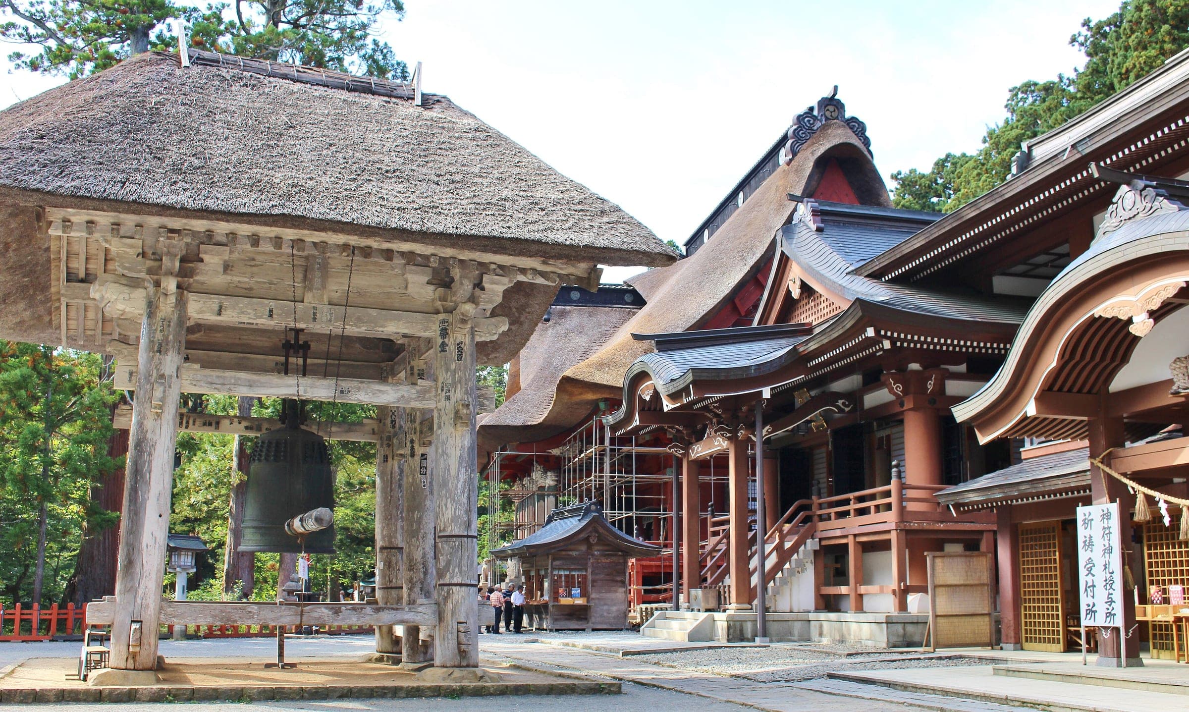 A thatched belfry stands before the red halls of the Sanjin Gosaiden on the summit of Mount Haguro.
