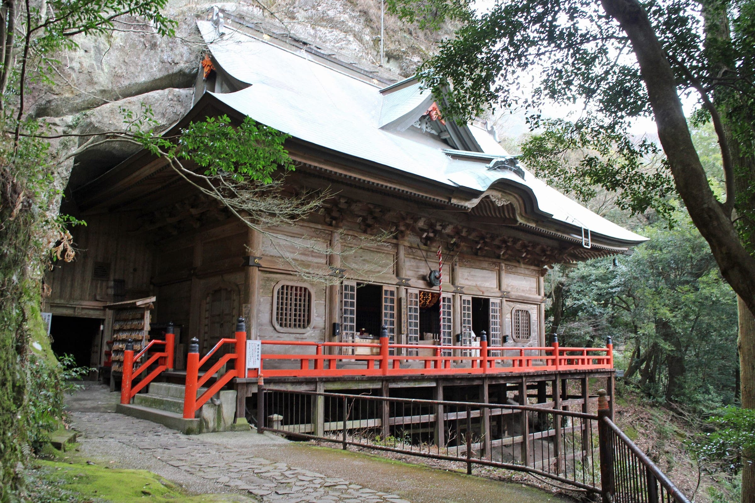 Futago-ji's Okunoin hall stands against a rock cliff behind a red wooden railing.