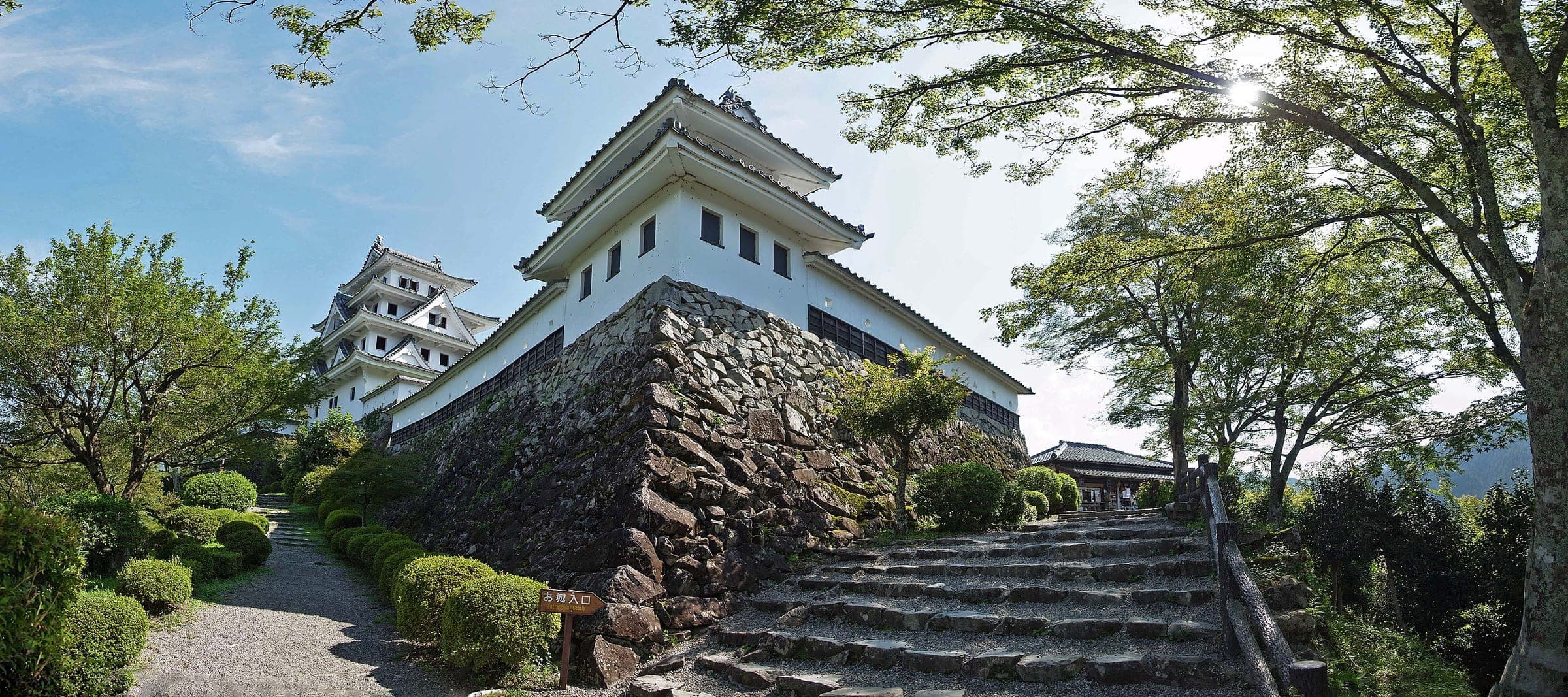 The white wooden keep of Gujo Hachiman Castle stands on stone walls above the town