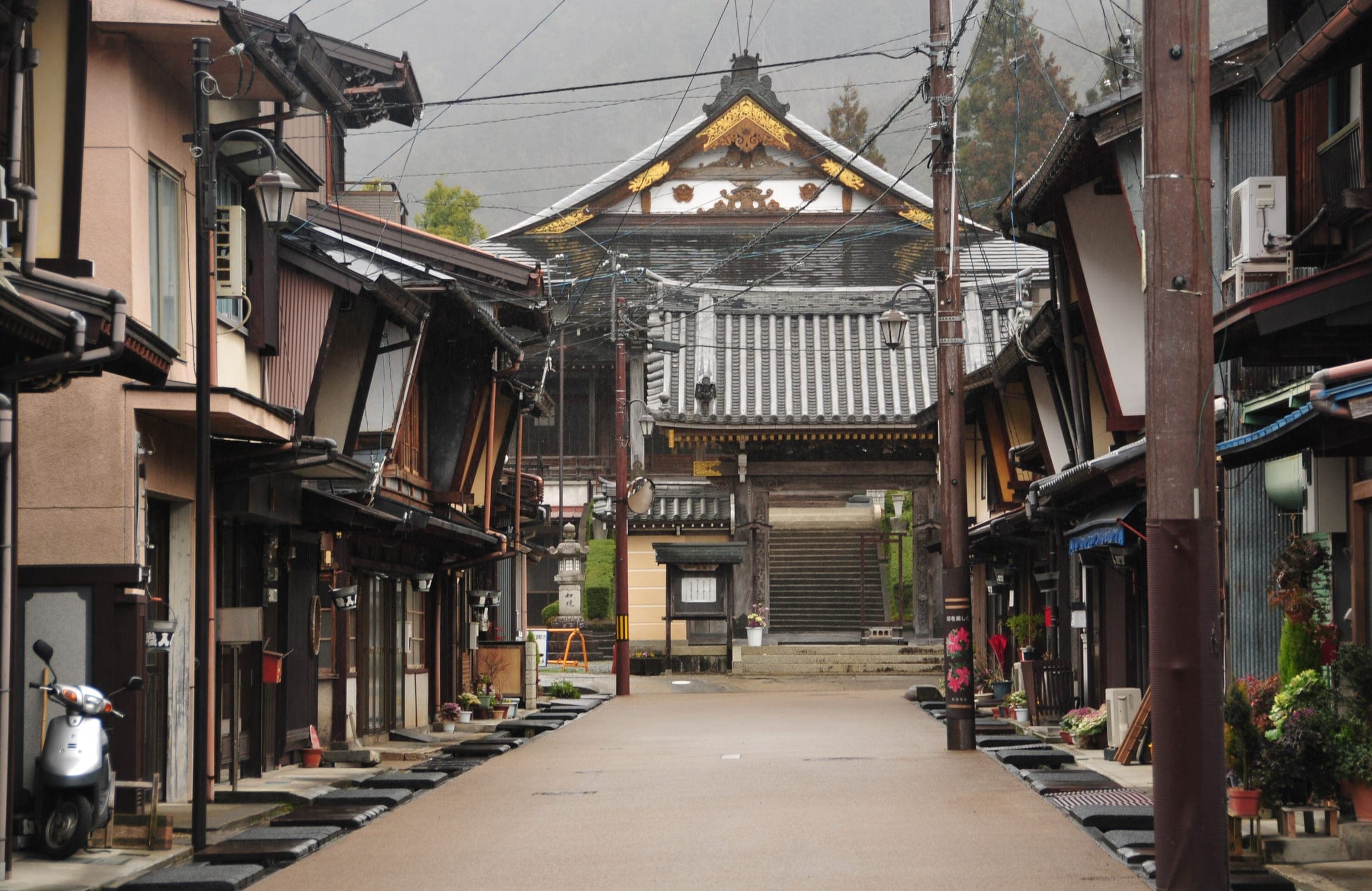 Old wooden townhouses line a quiet street in the Kitamachi district of Gujo-Hachiman