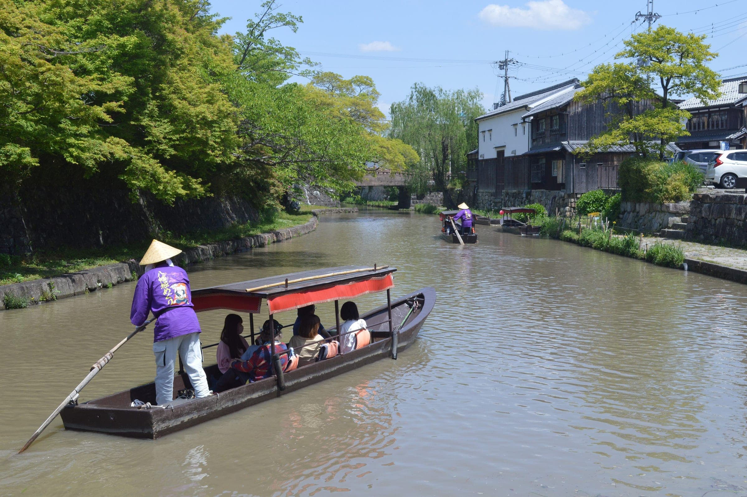 A boatman poles a covered boat along the Hachiman-bori Canal in Omihachiman in May