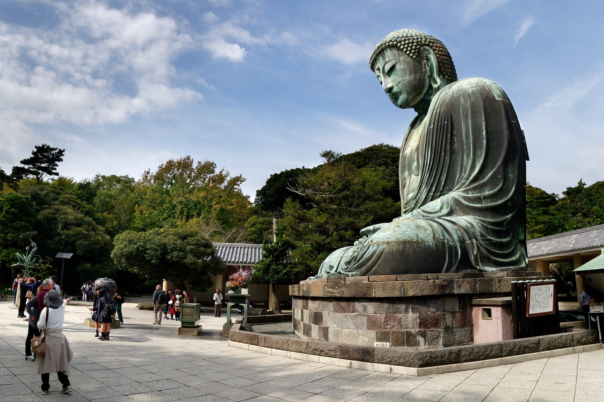 Visitors stroll the courtyard of Kotoku-in beneath the seated bronze Great Buddha of Kamakura.