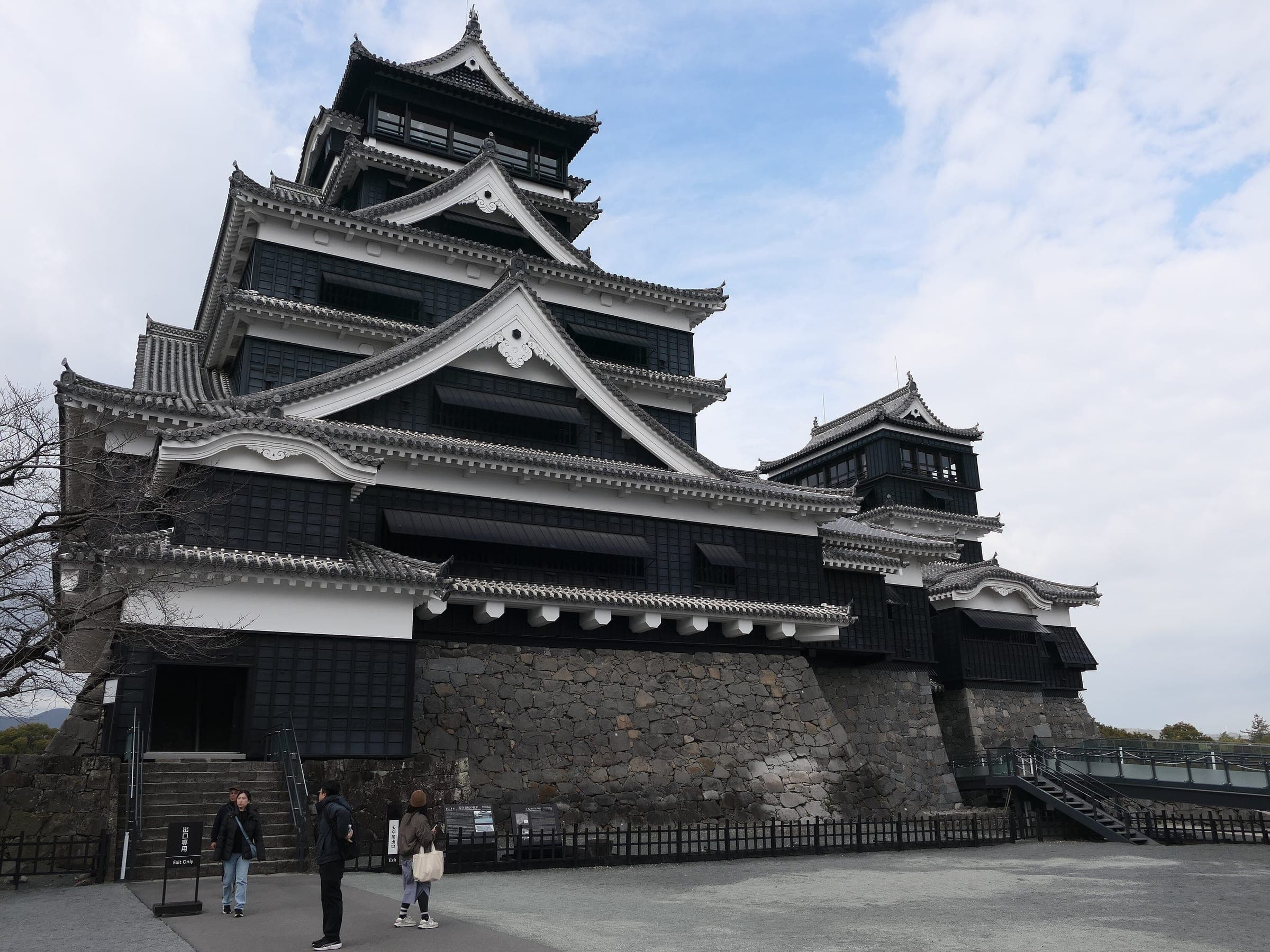 Kumamoto Castle's restored black keep stands on its curved stone base above the Honmaru courtyard.