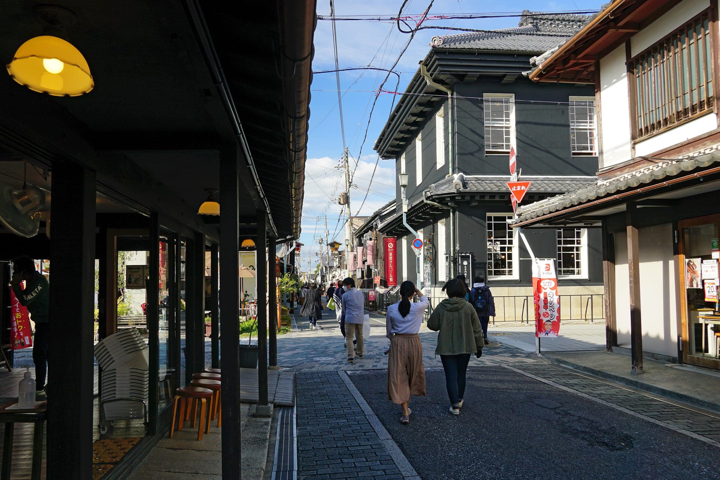 Visitors walk past the black-walled merchant houses of Kurokabe Square in Nagahama
