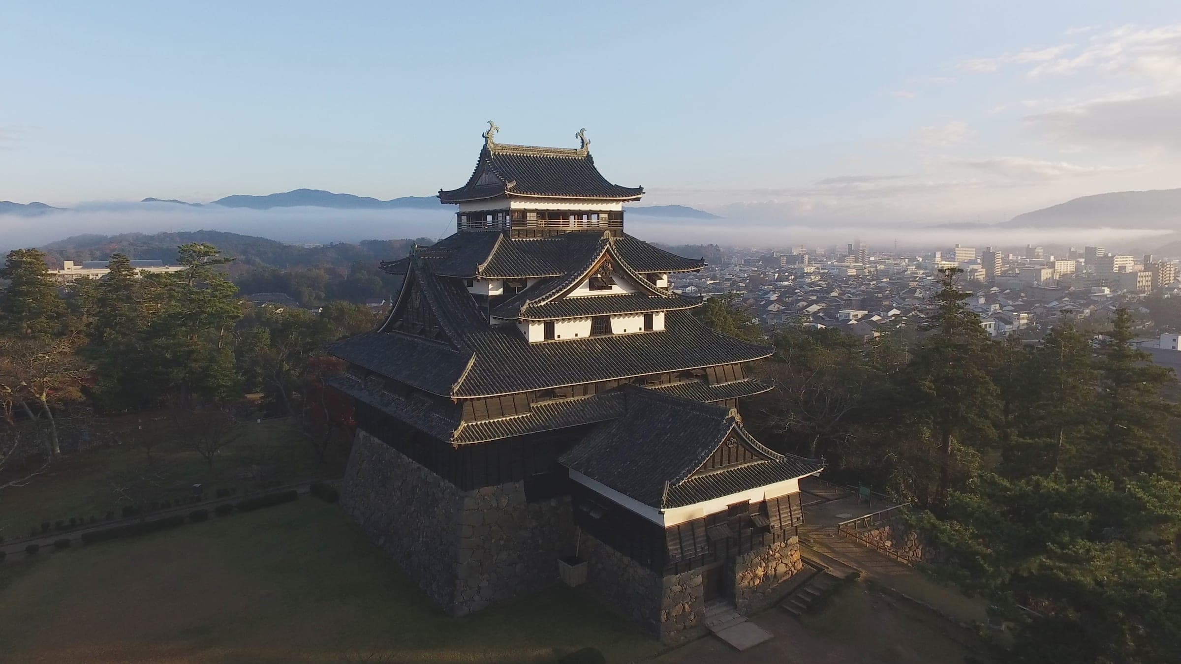 Morning mist lies over Matsue behind the dark keep of Matsue Castle