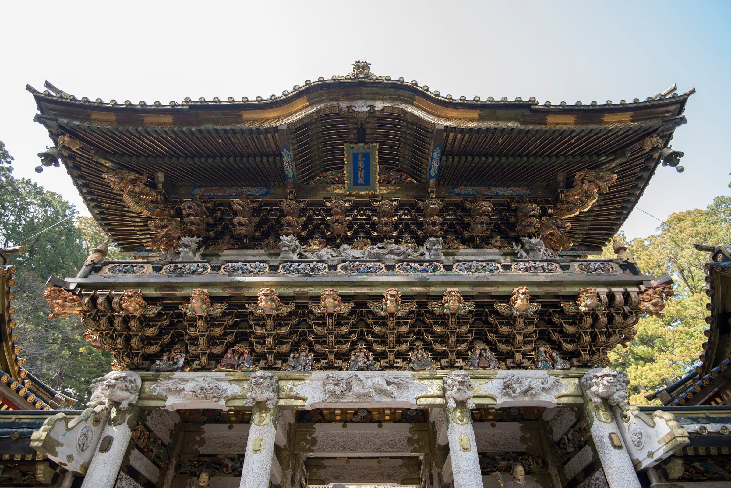 Carved and gilded brackets crowd the eaves of the Yomeimon gate at Nikko Toshogu