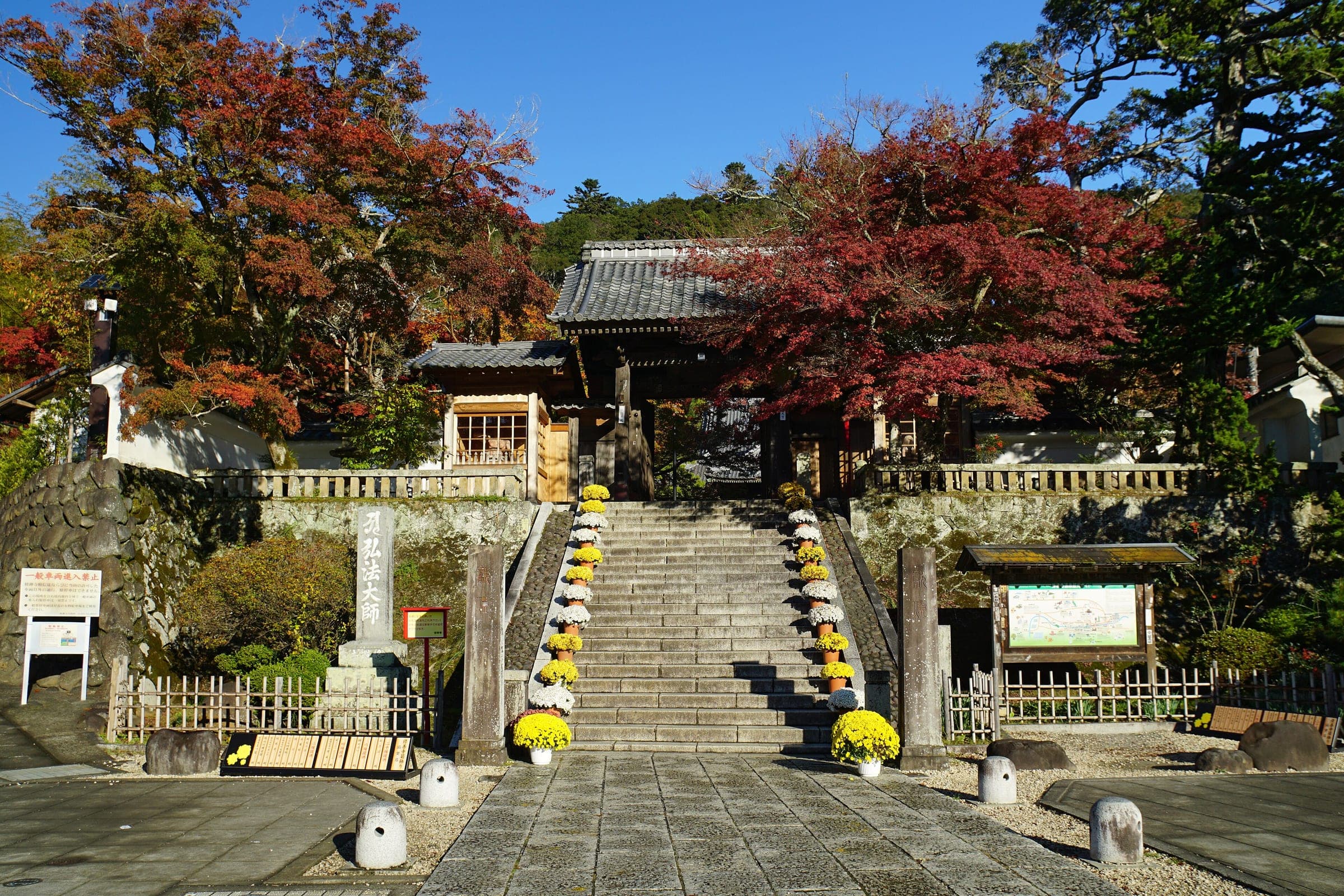 Red maples frame the stone steps and main gate of Shuzen-ji temple in Shuzenji in November.