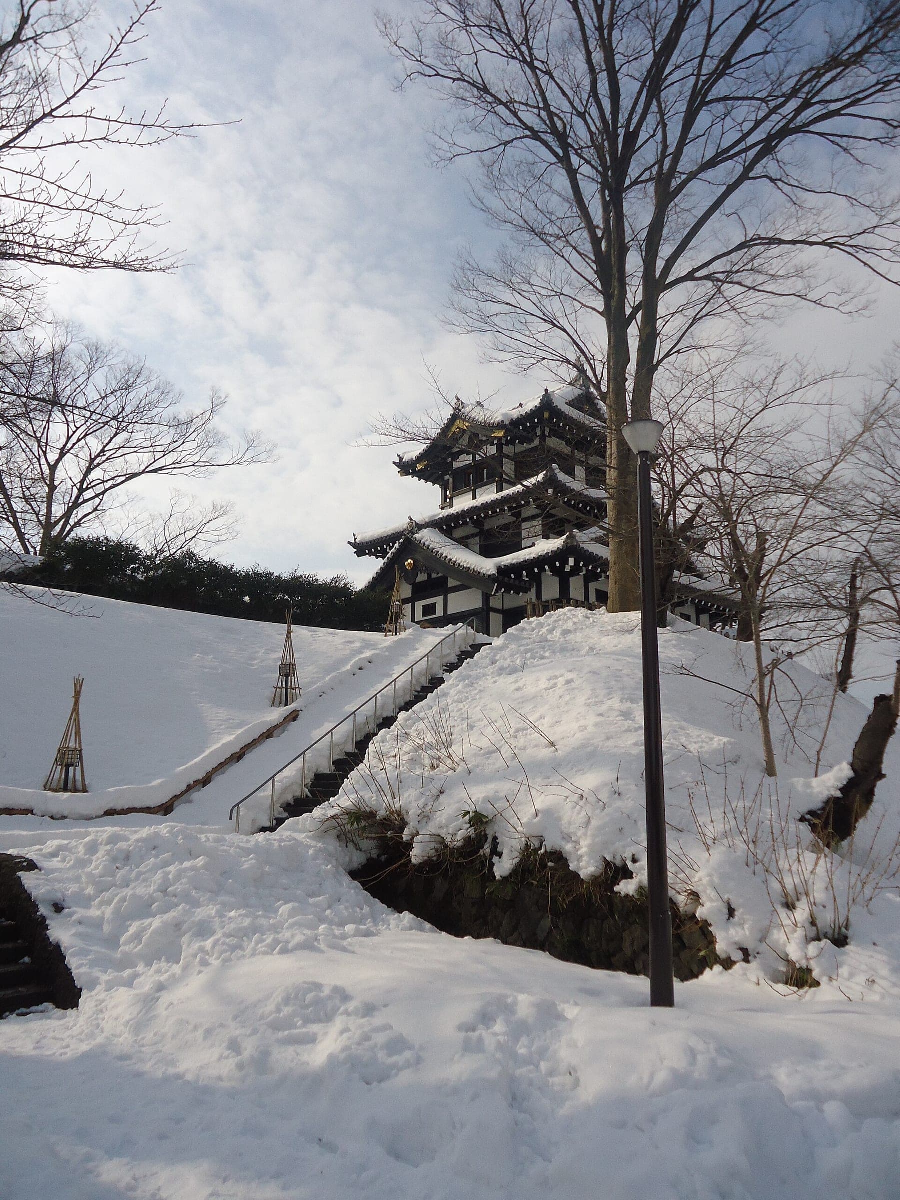 Snow covers the mound below the rebuilt three-storey turret at Takada Castle in January