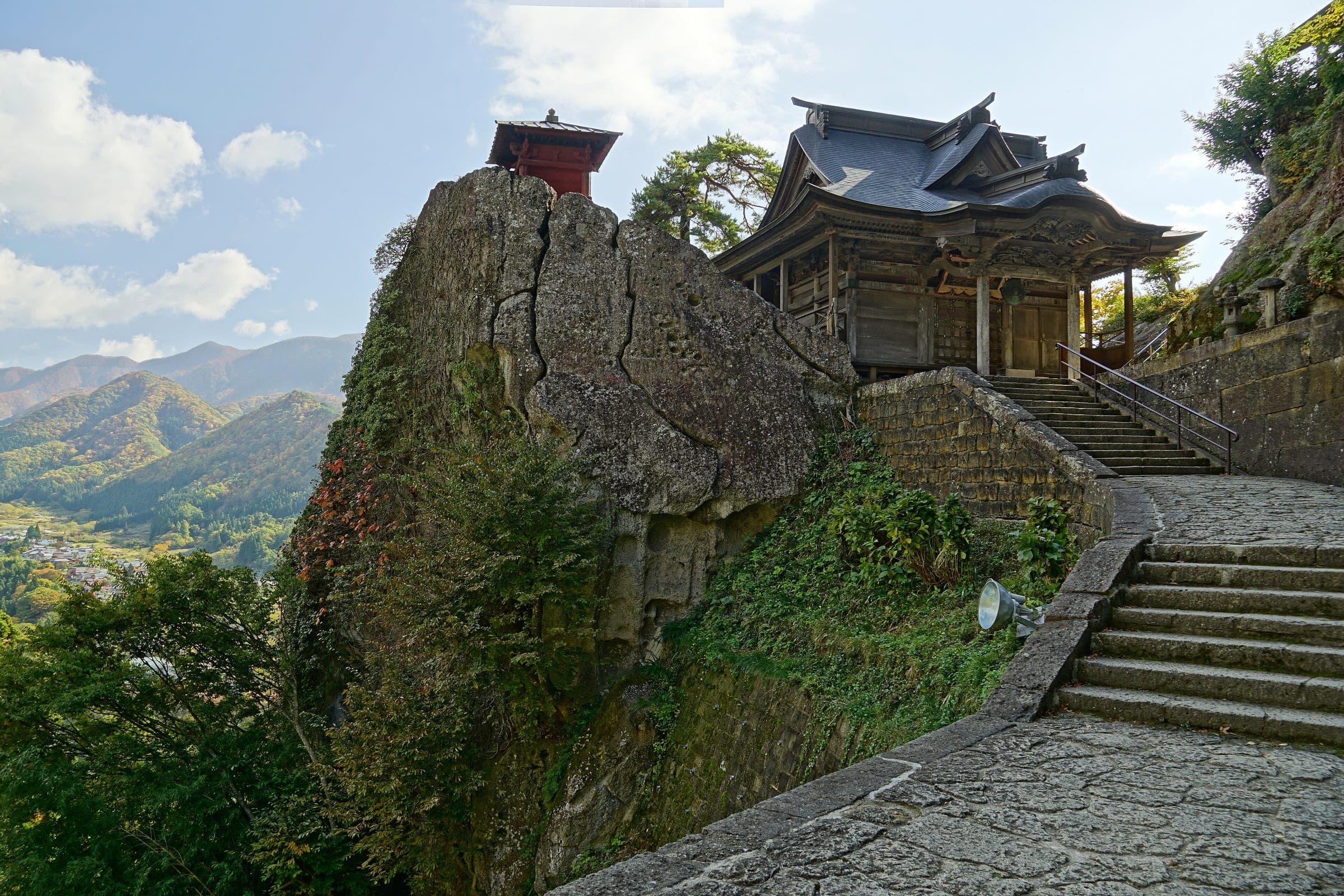 The small red Nokyodo sits atop a rock spur beside the Kaisando hall high on Yamadera.