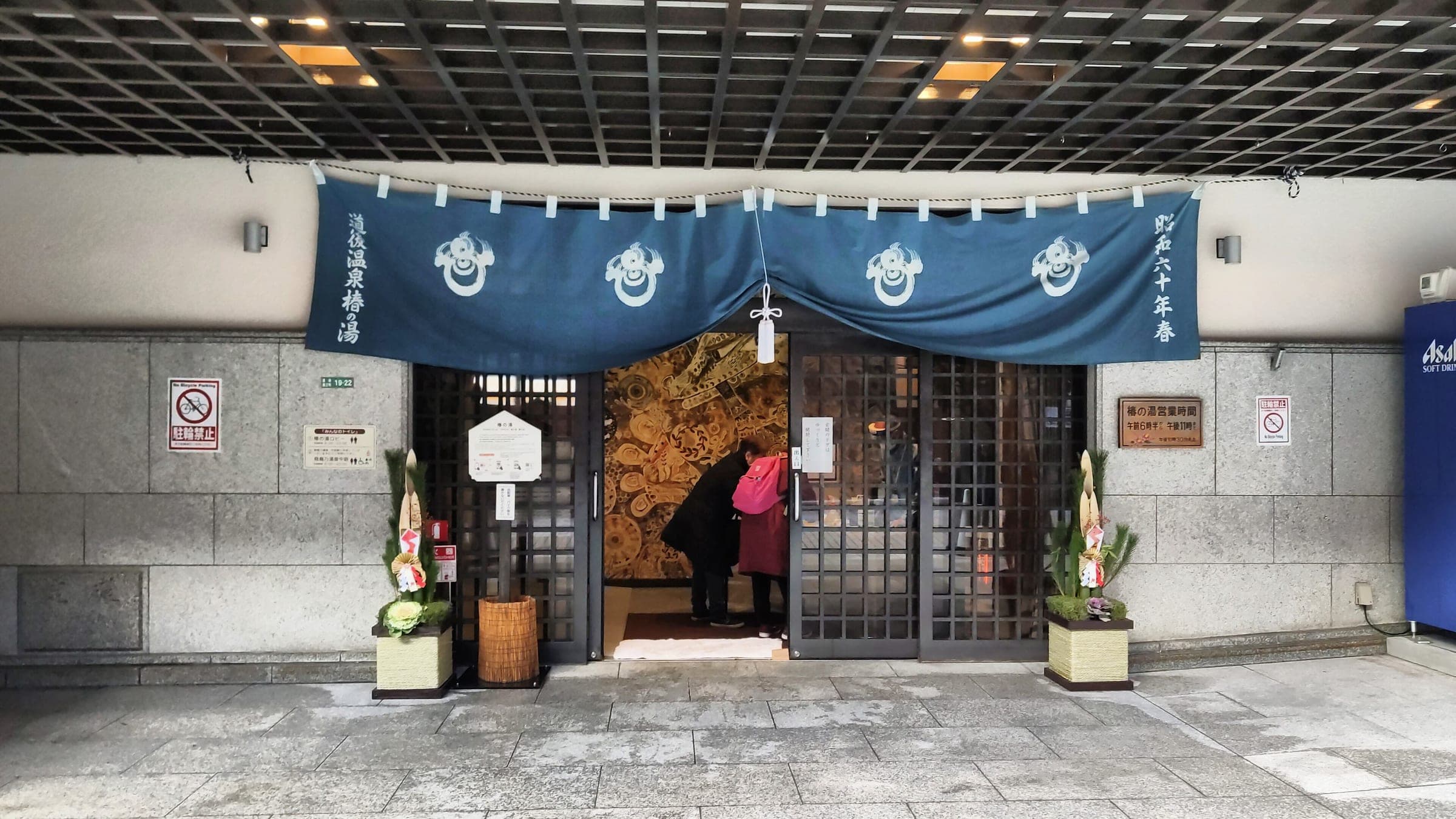 Indigo noren curtains hang over the entrance of Dogo Onsen Tsubaki-no-Yu in Matsuyama.