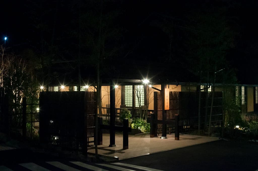 Lanterns light the bamboo garden and timber buildings of Hakone Yuryo after dark.