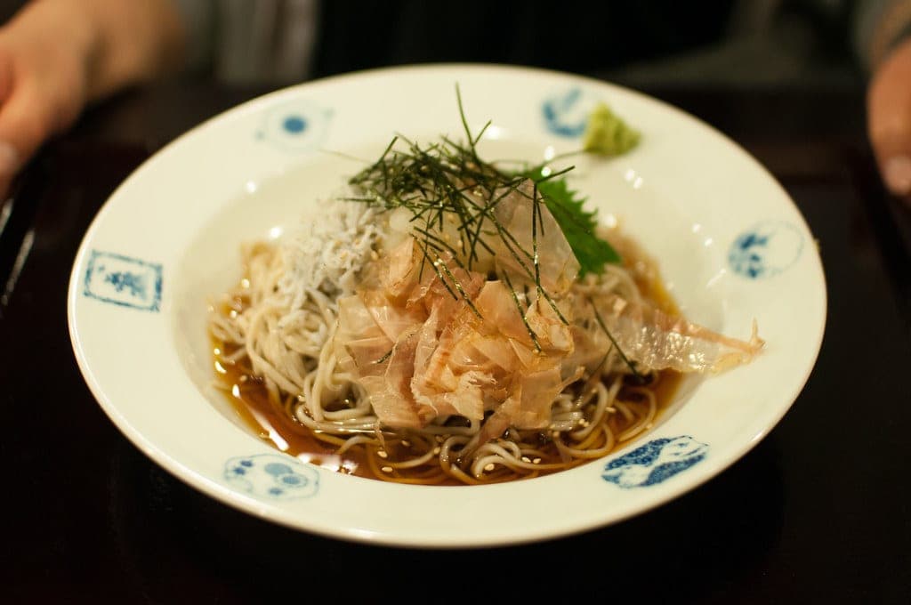 Cold soba topped with grated radish and plum comes in a blue-patterned bowl at Hakone Yuryo.