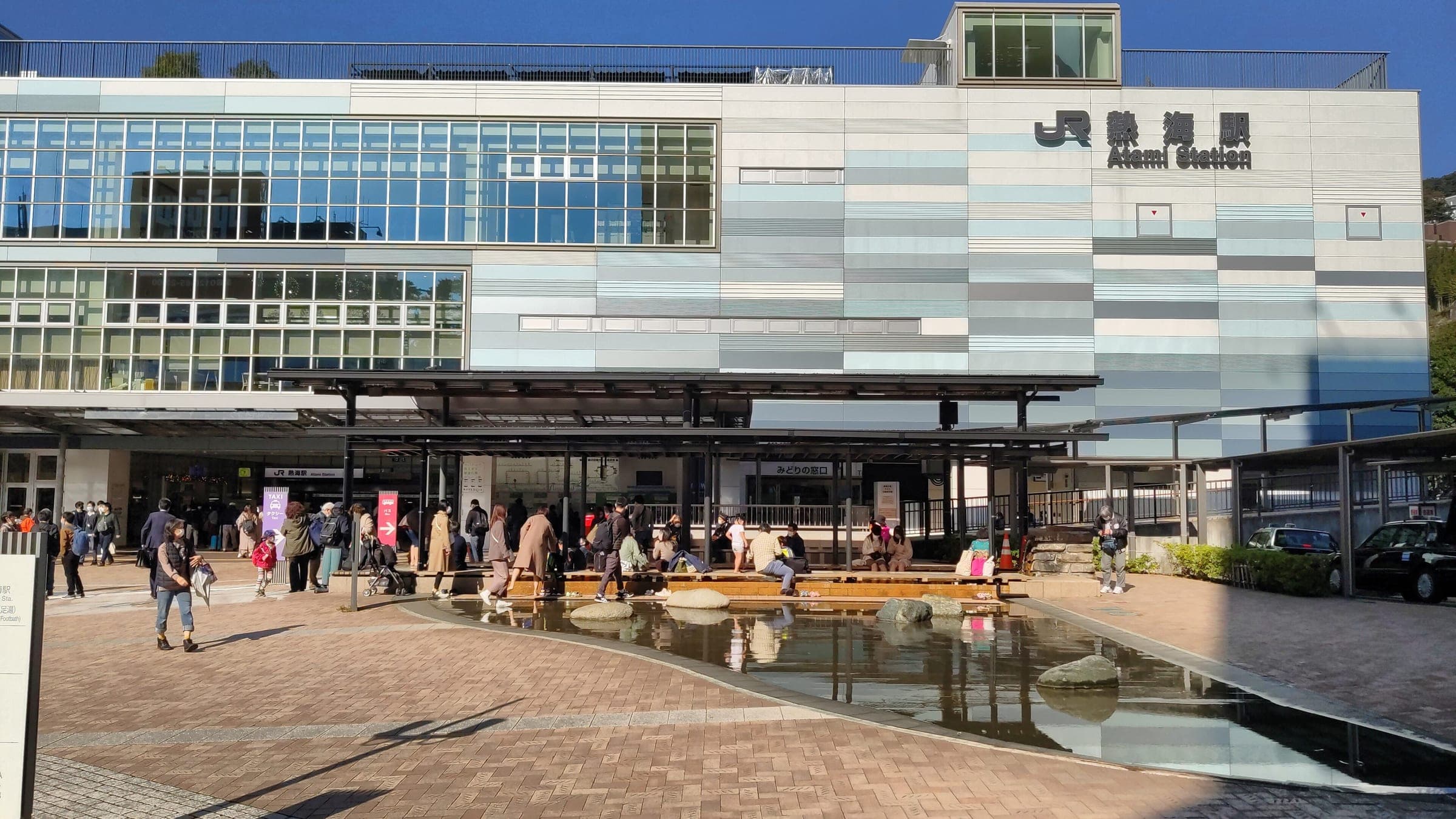 The Ieyasu no Yu footbath runs under a canopy on the plaza in front of JR Atami Station.