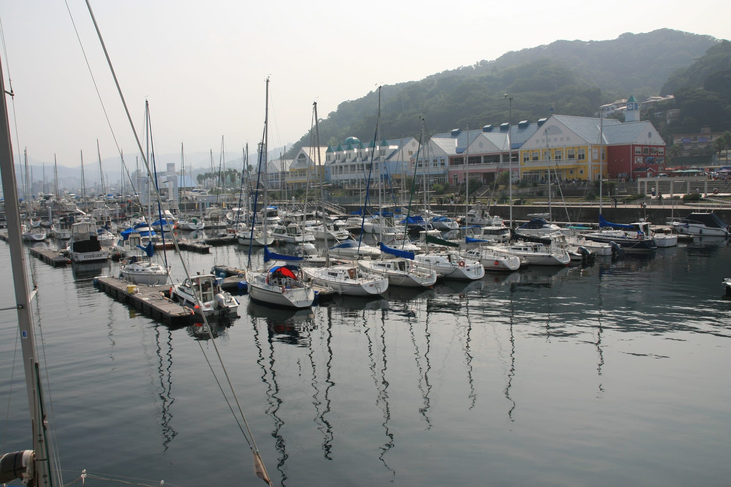 Yachts sit in the marina below the pastel buildings of Ito Marine Town on Route 135.