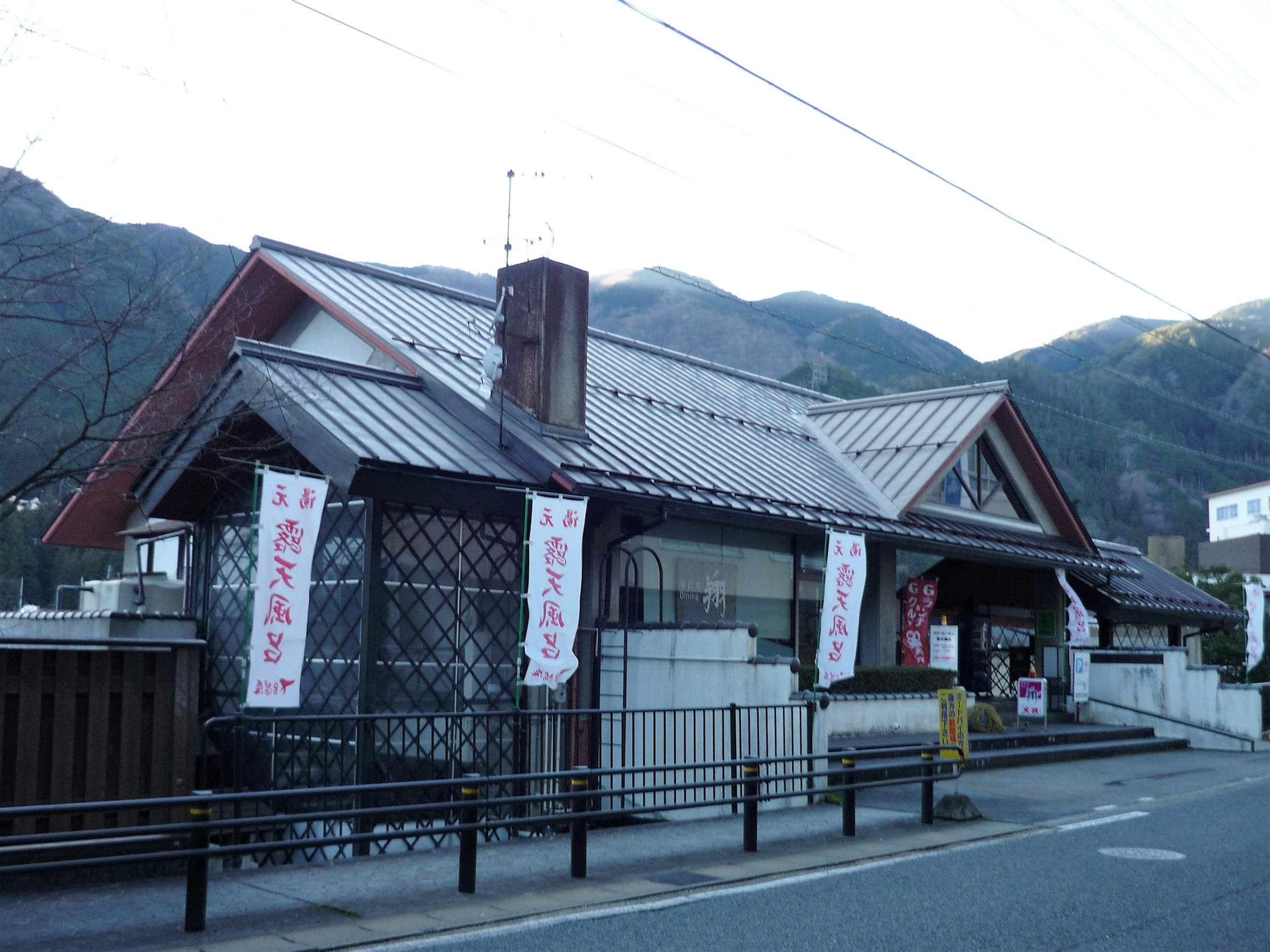 Banners hang outside the gabled entrance of the Kur Garden Rotenburo bathhouse in Gero Onsen