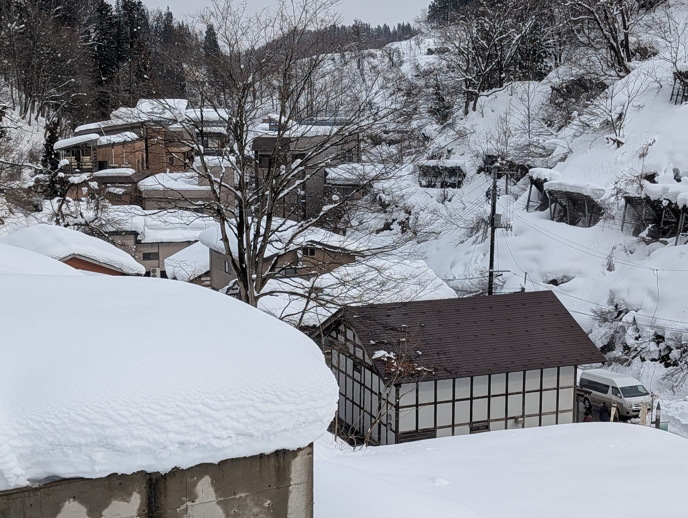 Thick snow buries the roofs of Matsunoyama Onsen where the village climbs a steep valley side