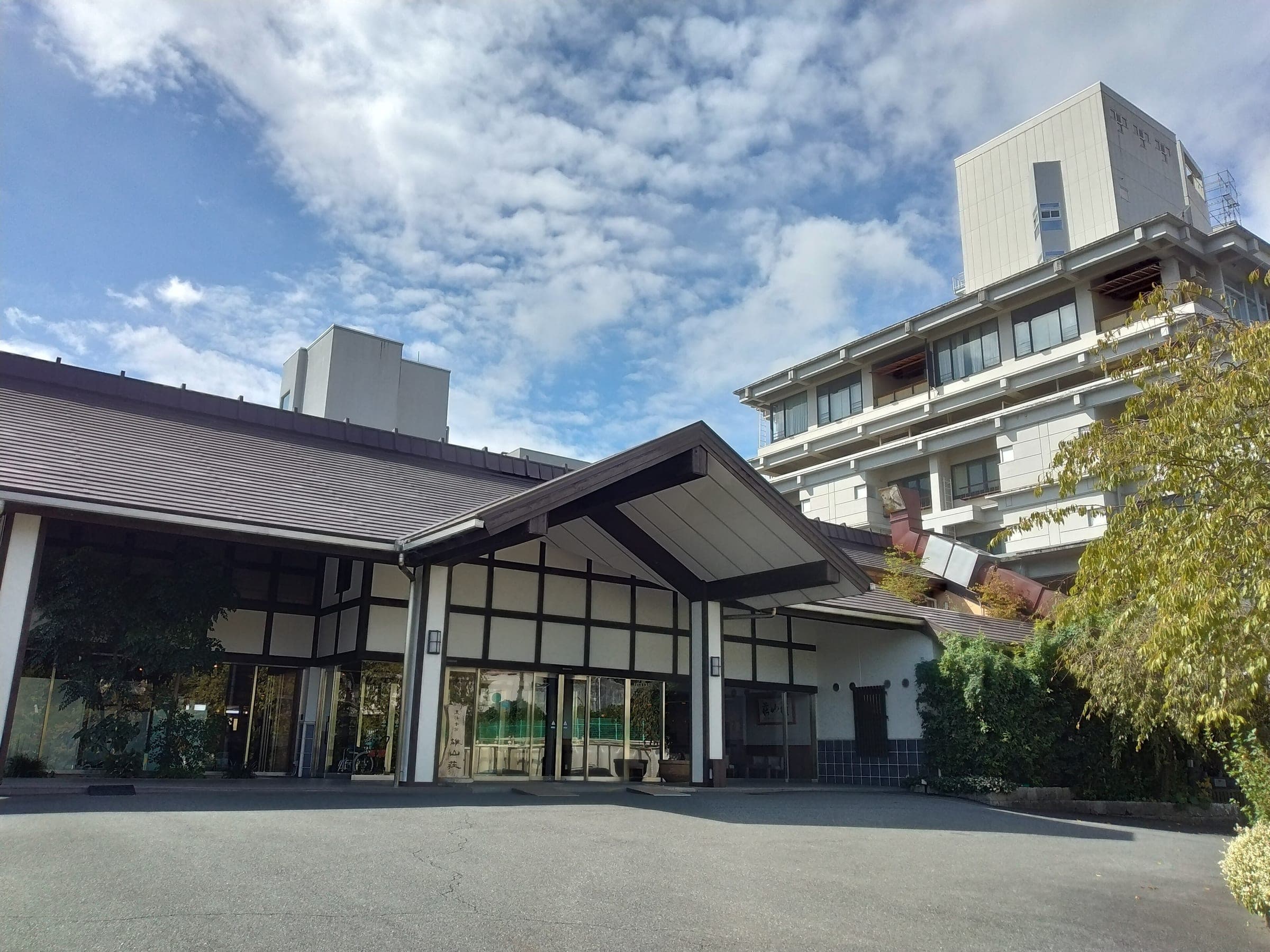A ryokan entrance with a broad tiled porch faces the street at Ogoto Onsen in Otsu