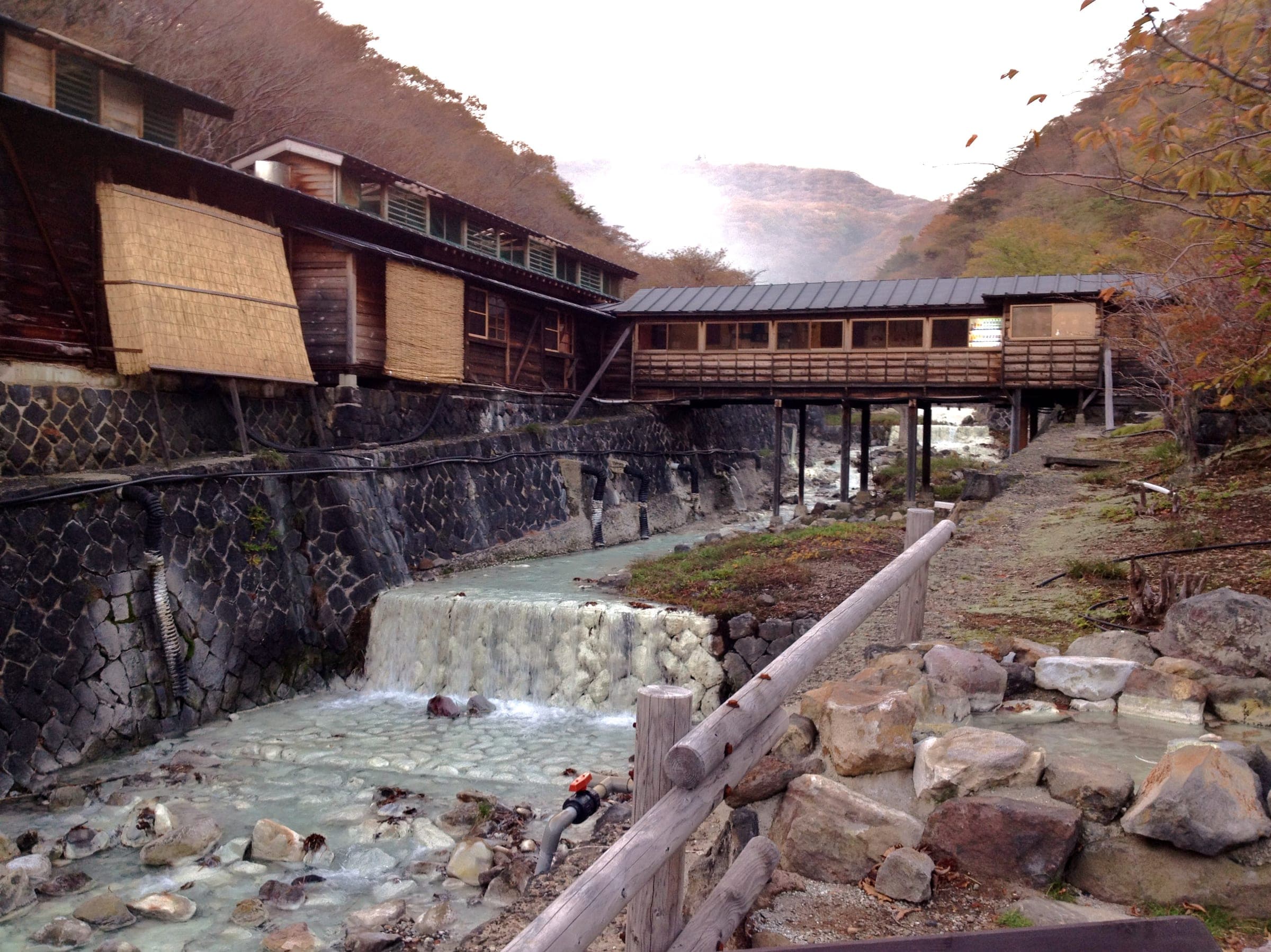 A covered bridge crosses the milky Yukawa stream to Shika no Yu at Nasu Yumoto