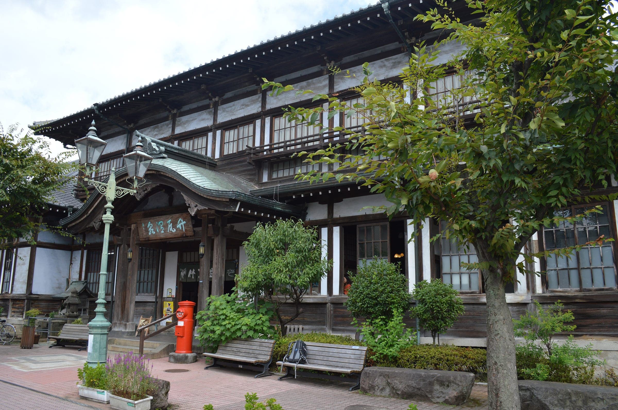 The tiled roofs and carved gable of Takegawara Onsen face a small square in central Beppu.