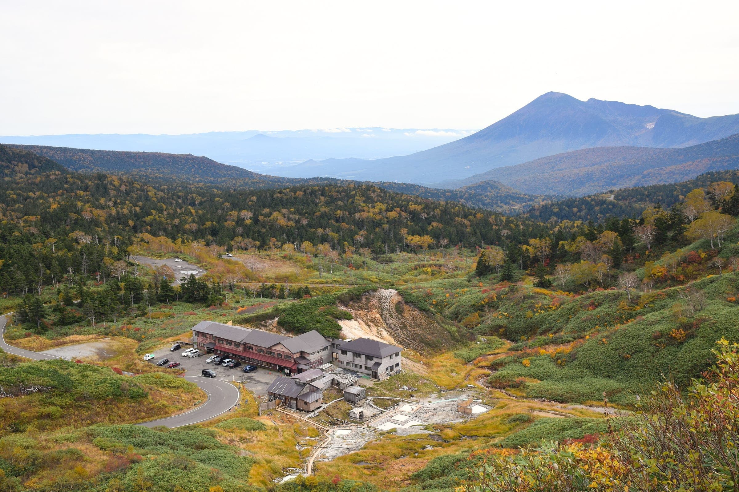 Toshichi Onsen sits among steaming slopes on the Hachimantai plateau with Mount Iwate on the skyline.