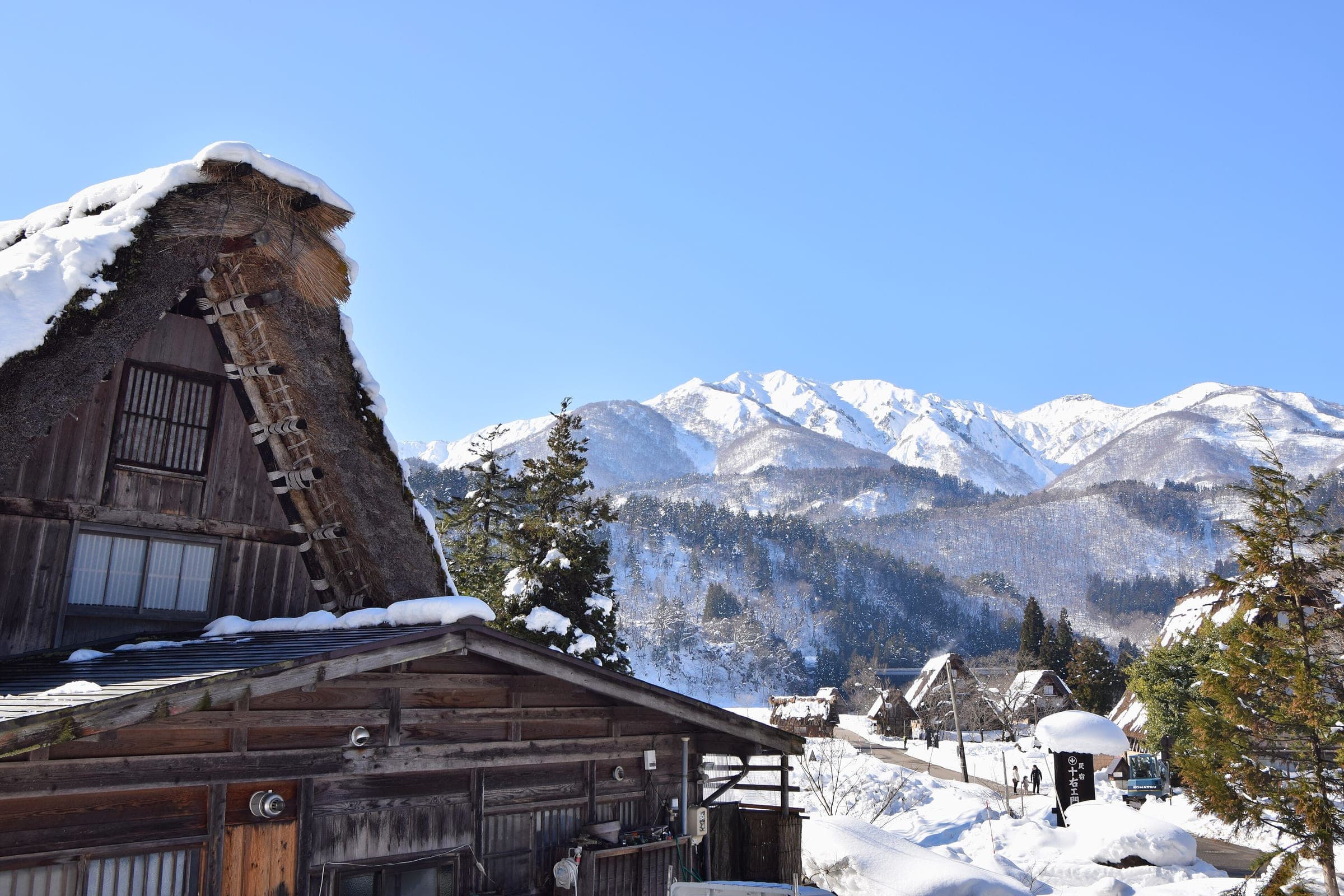 A snow-laden thatched farmhouse in Shirakawa-go looks out on white peaks above the Shogawa valley