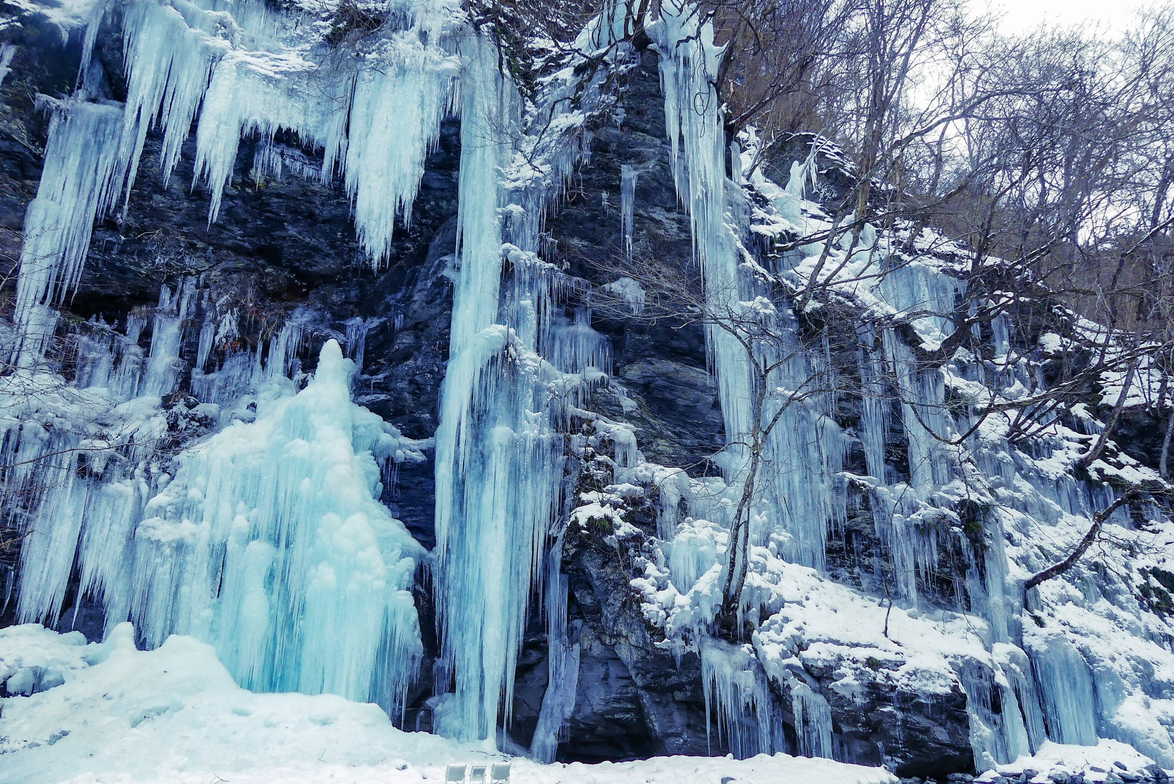 Blue-white icicles hang over a rock face at Misotsuchi beside the Arakawa River in Chichibu in February