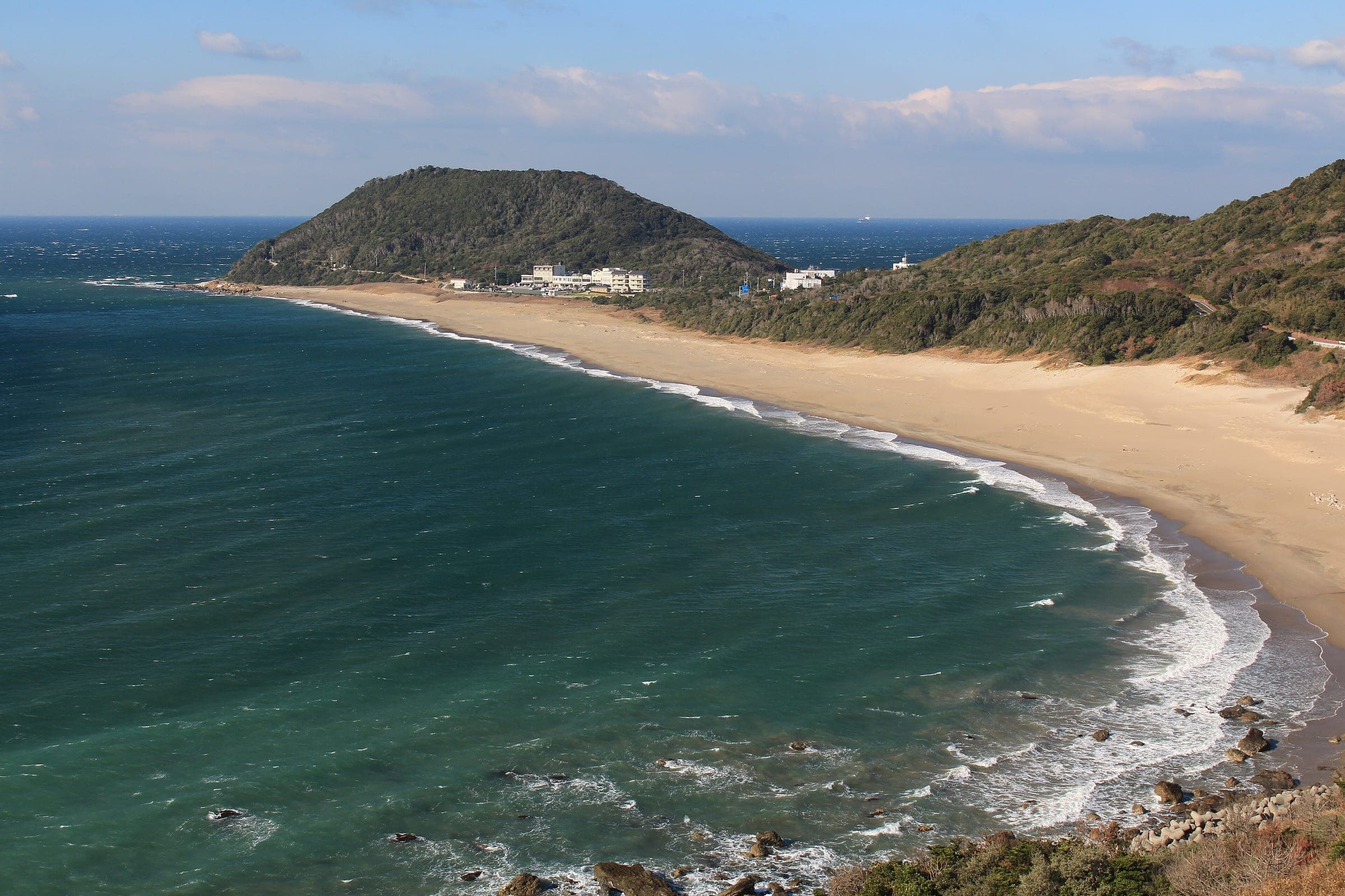 Koiji Beach curves toward the green hill of Cape Irago at the tip of the Atsumi Peninsula in December