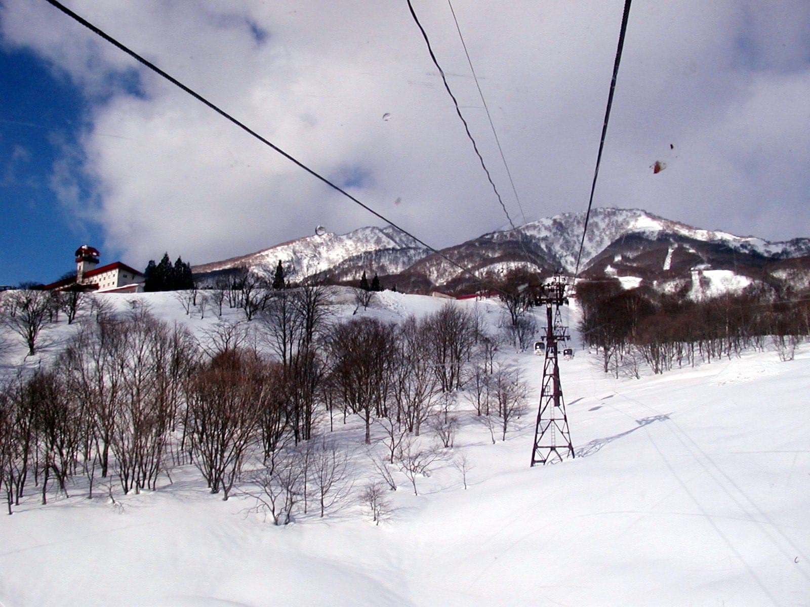 The Myokokogen Skycable climbs past Akakura Kanko Hotel toward the snowy Myoko peaks
