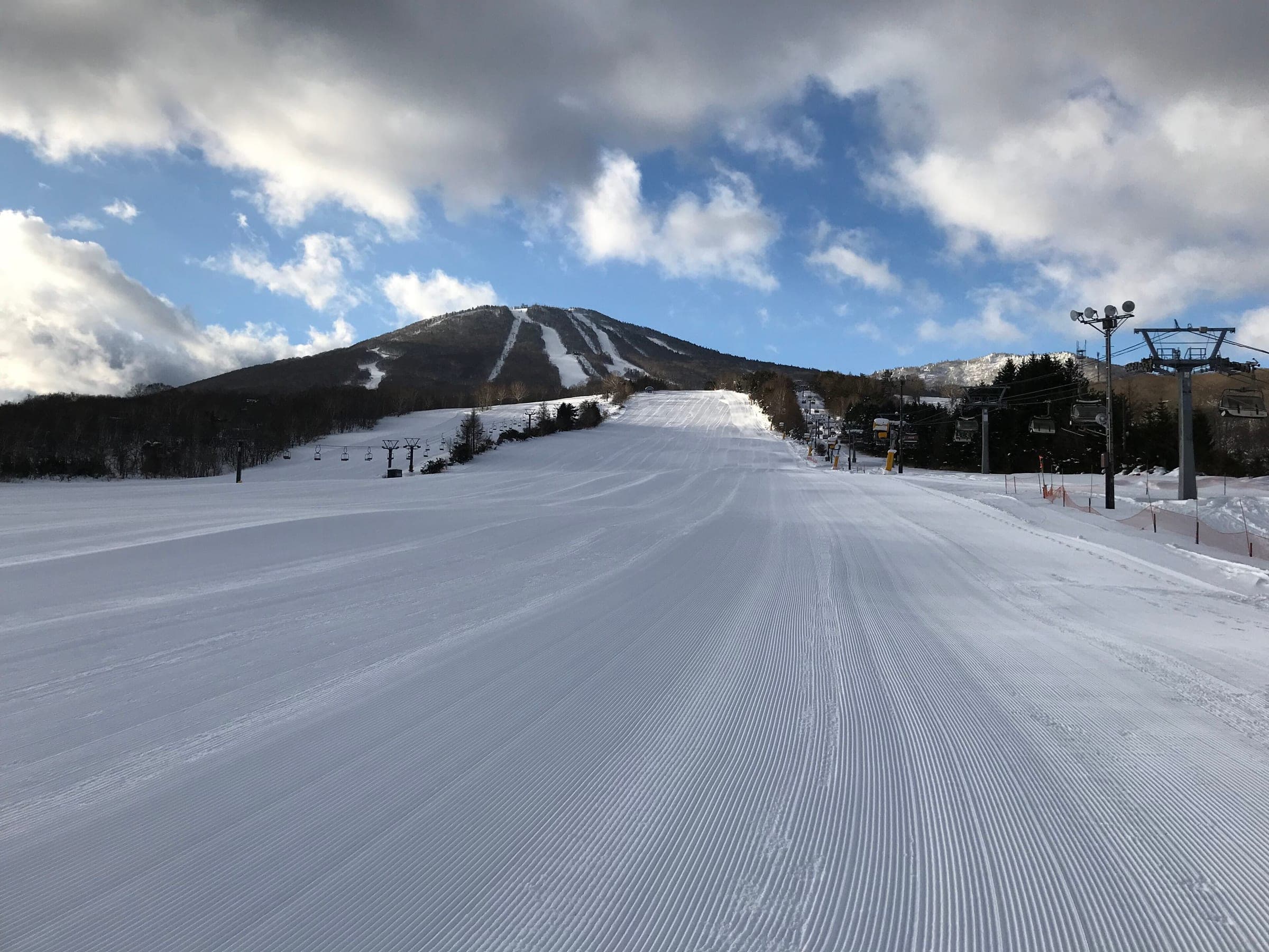 Fresh corduroy on the Shirakaba run at APPI leads toward the cut trails of Mount Maemori.