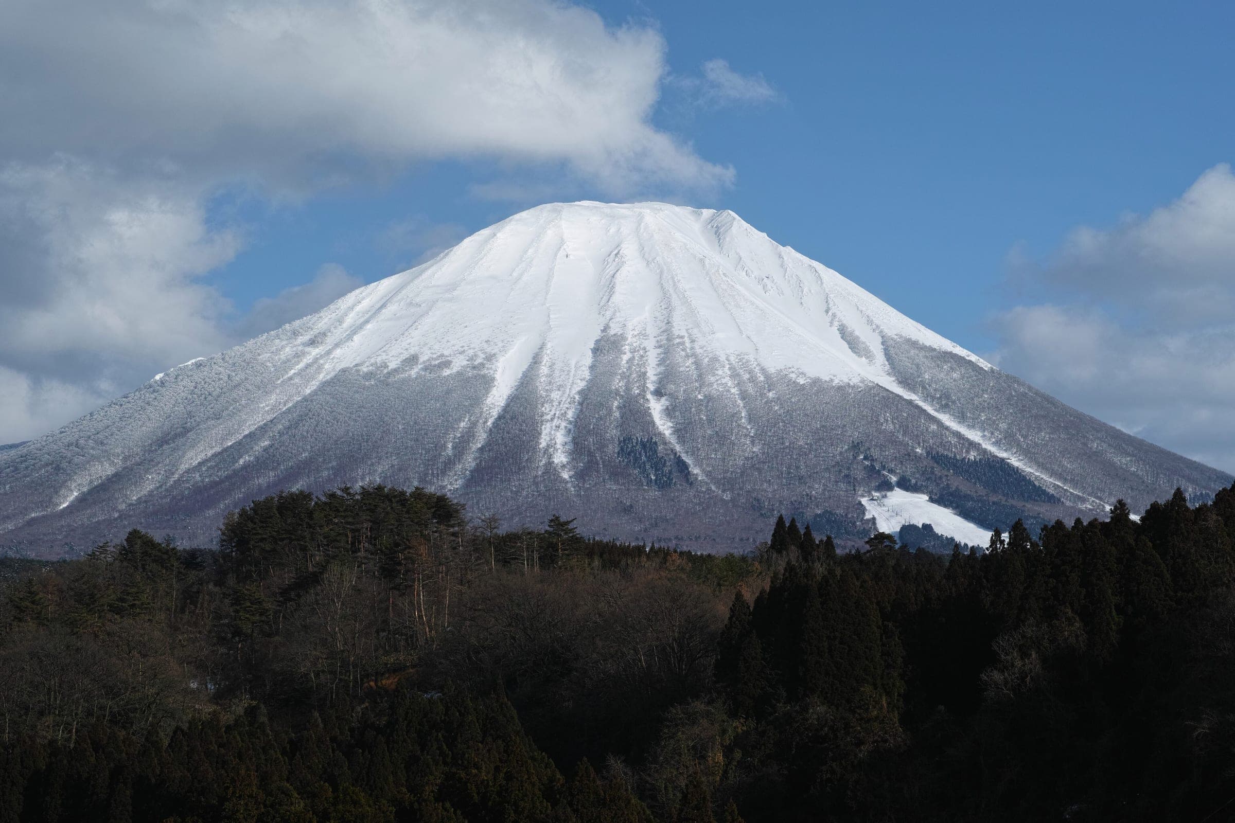 Snow covers the west face of Mount Daisen above the forests of Houki in February