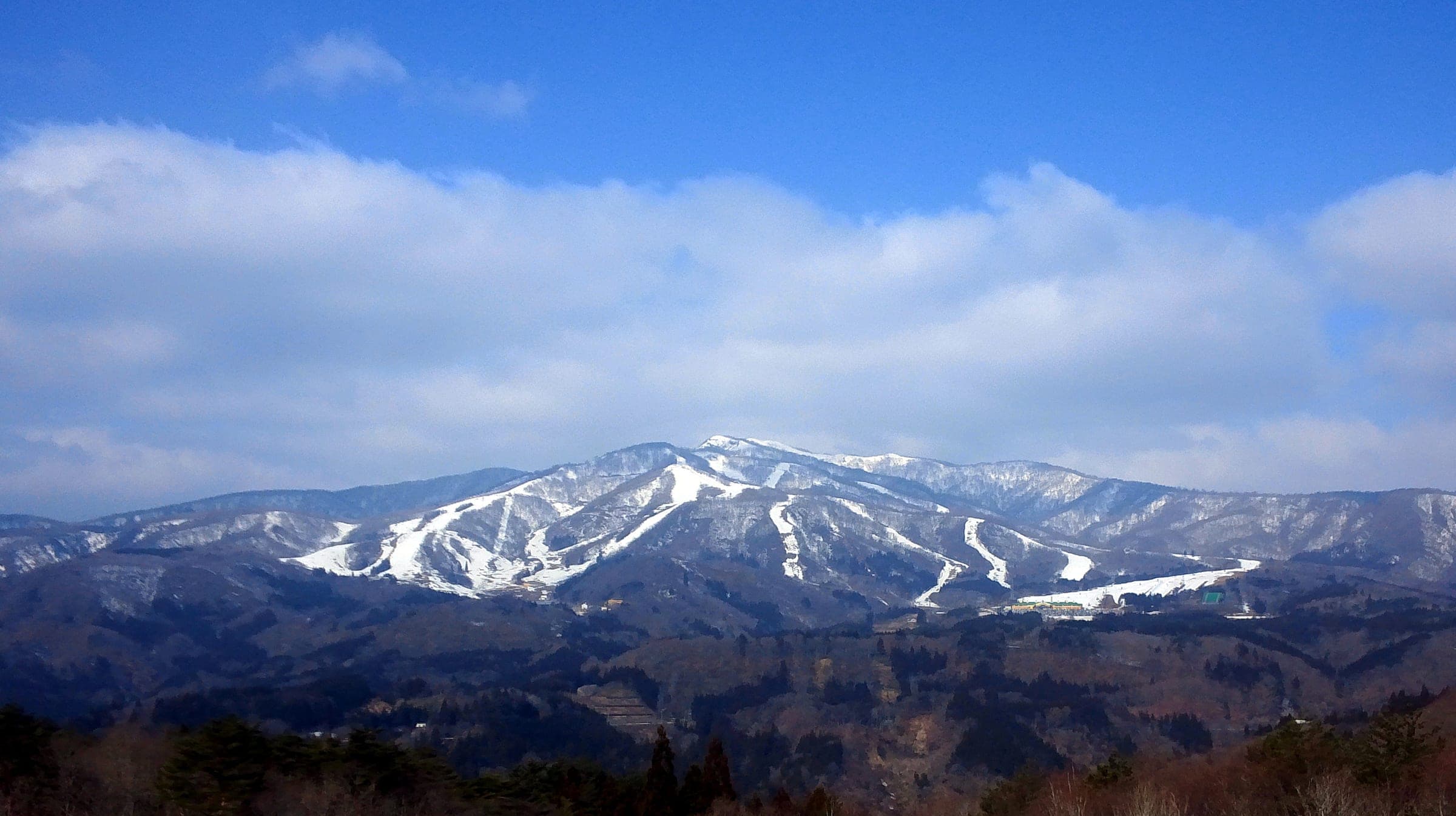 Takasu Snow Park and Dynaland share the snowy flanks of Mount Dainichi under a blue spring sky