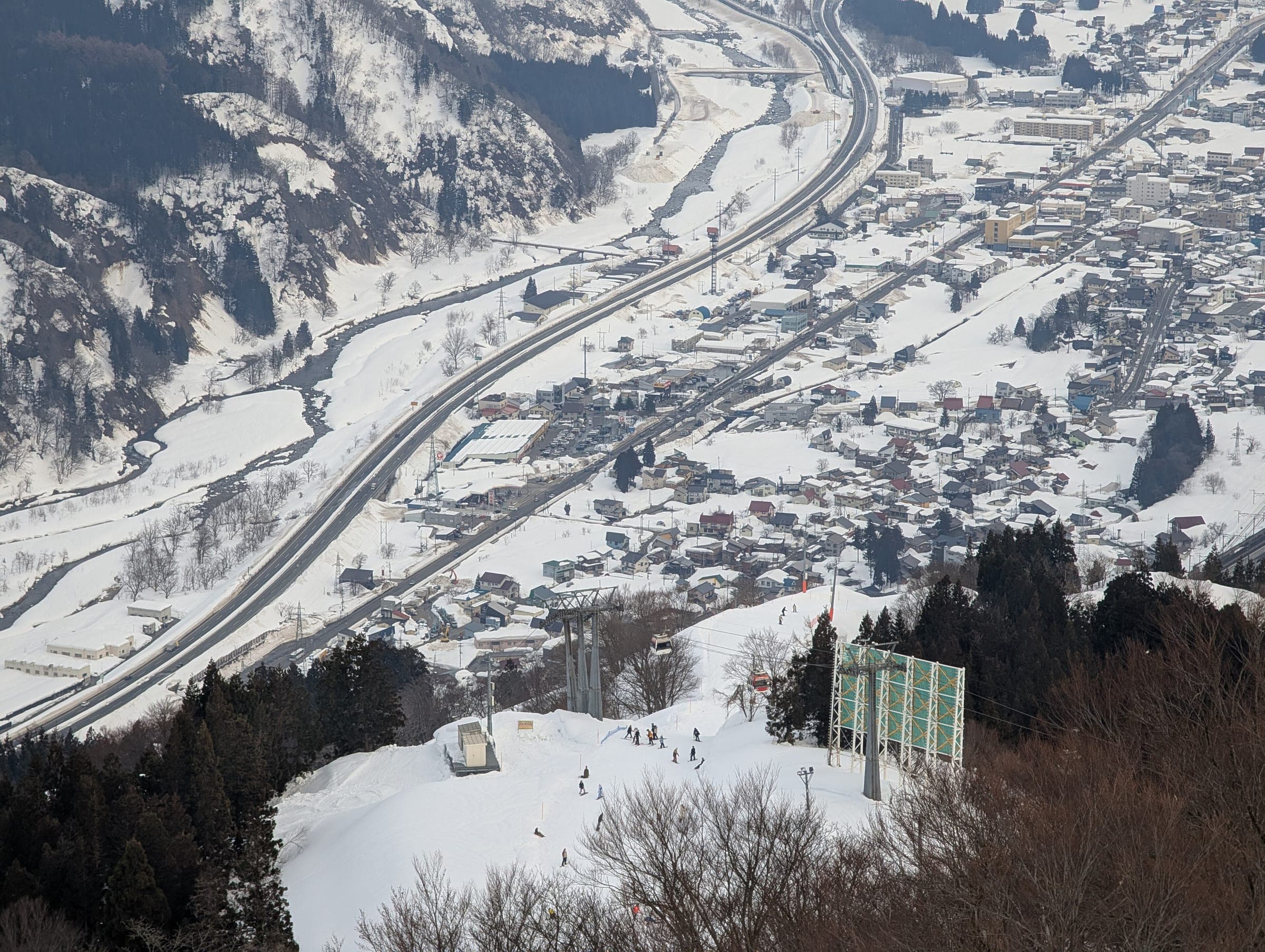 A run at GALA Yuzawa drops toward Yuzawa town and the Kan-Etsu Expressway in the valley