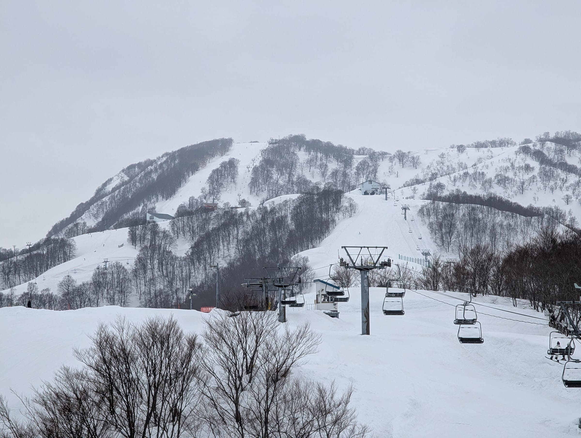 Chairlifts climb the open lower slopes of Ishiuchi Maruyama on an overcast March day