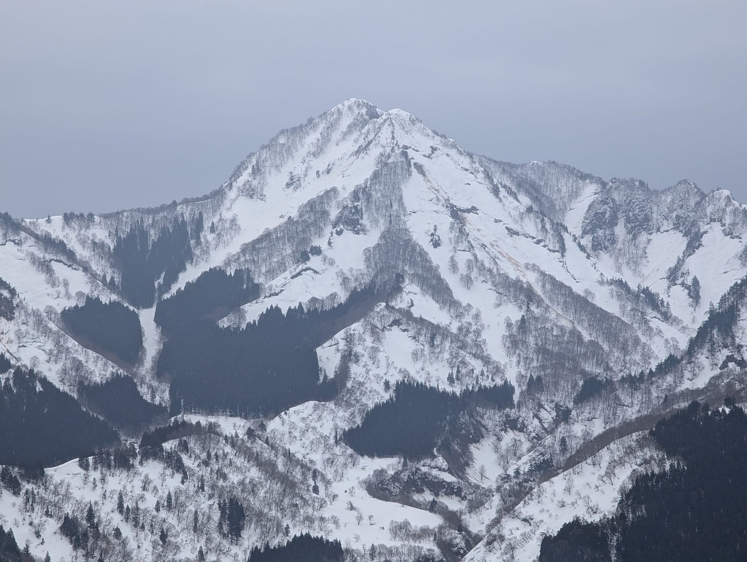 Mount Iiji rises in a sharp snowy pyramid across the valley from Ishiuchi Maruyama