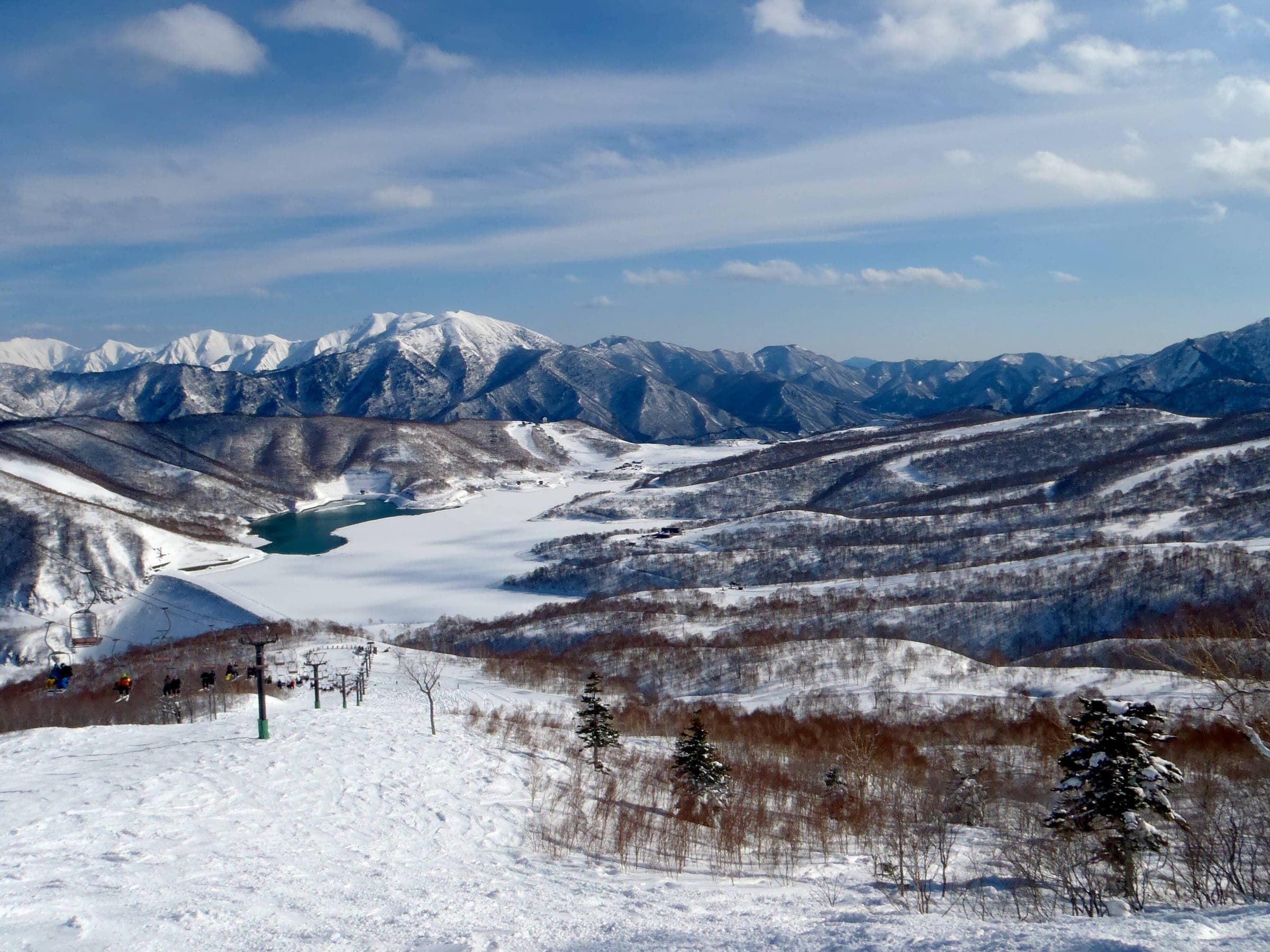 The frozen Kassa Dam lake lies below the Panorama Course at Kagura under snowy peaks