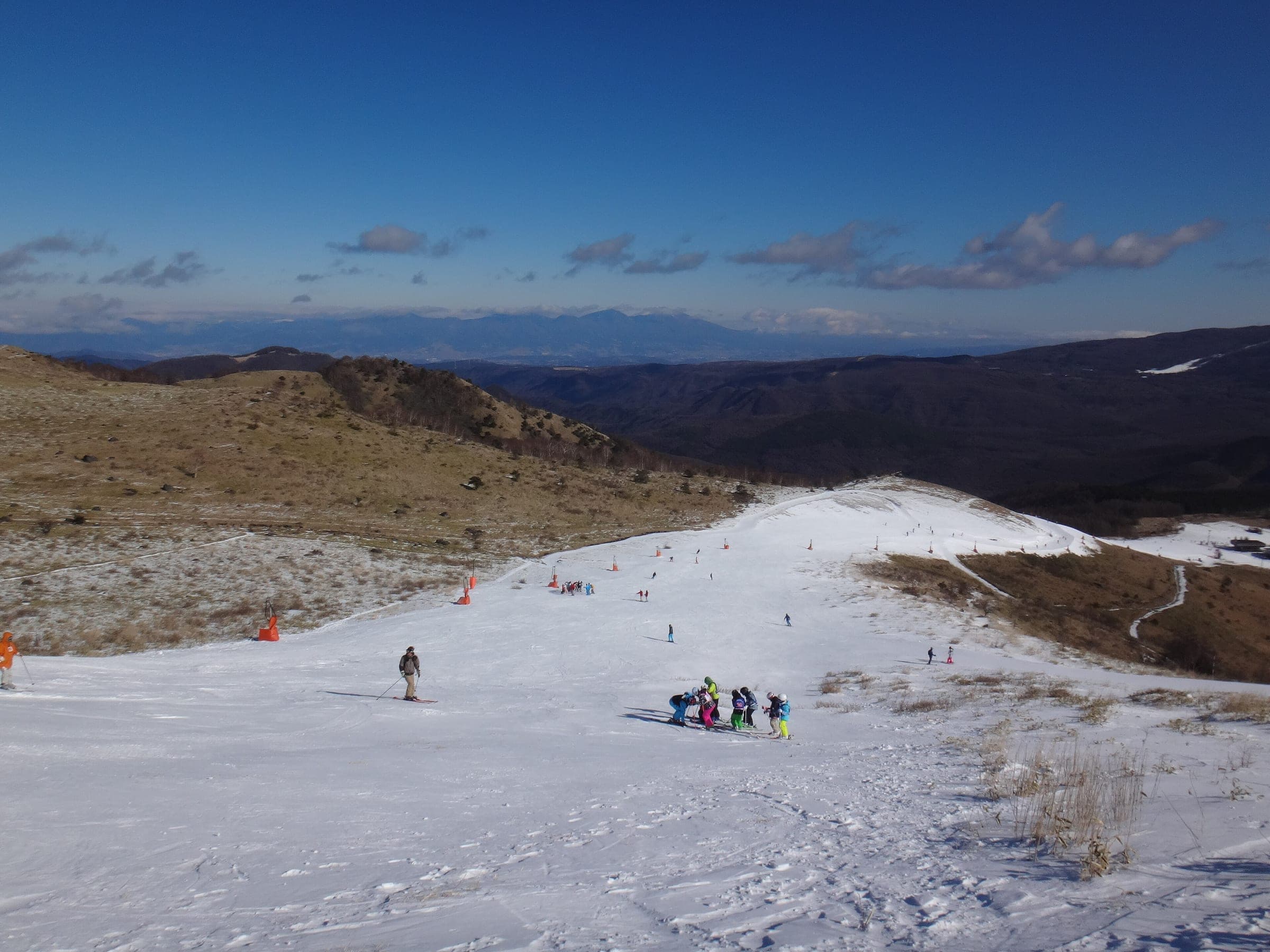 Skiers descend a wide upper run at Kurumayama Kogen SKYPARK in January