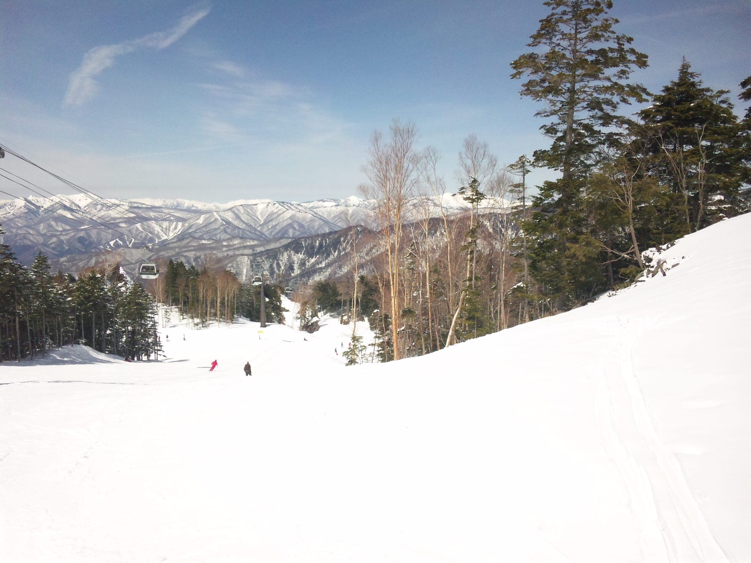 A wide run at Marunuma Kogen looks out over the snowy ranges of northern Gunma in April