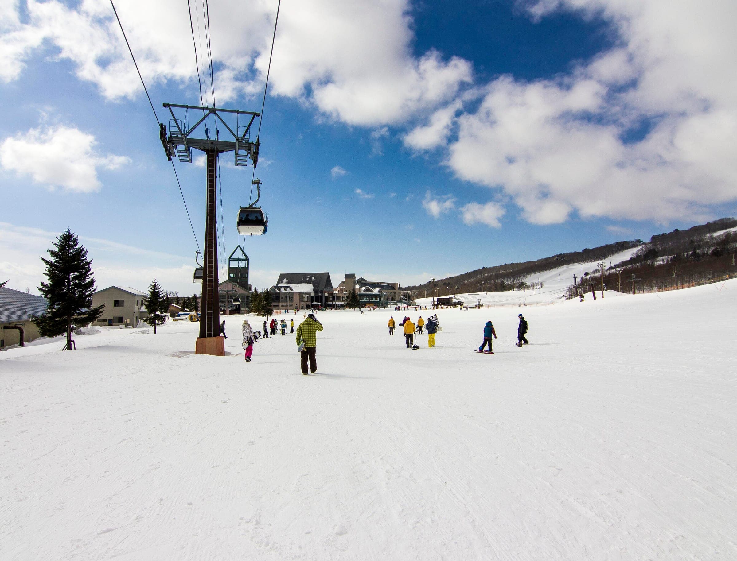Skiers and riders gather by a lift at the south base of NEKOMA Mountain, then called Alts Bandai.