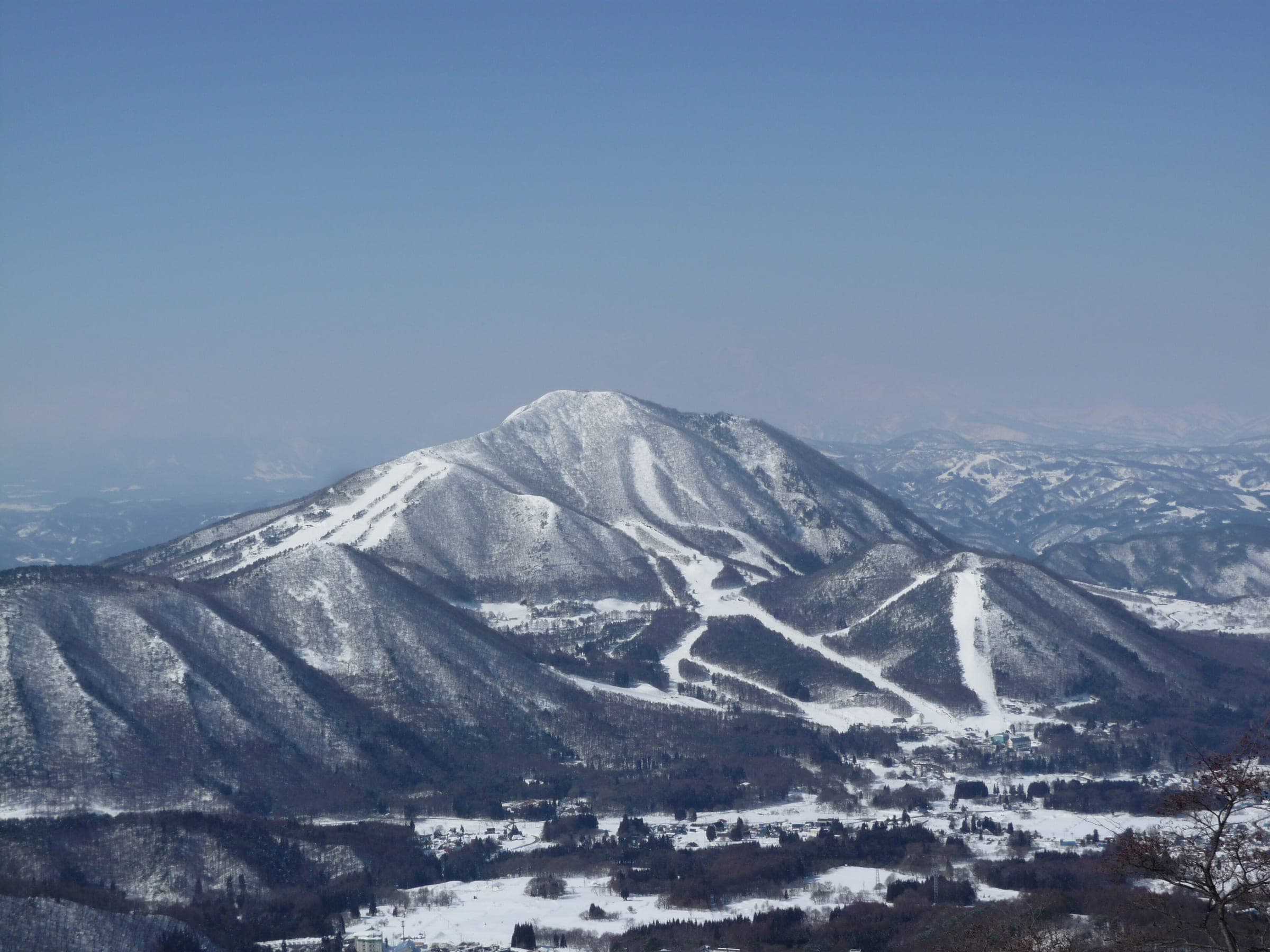 Mount Kosha and its ski runs rise above the Yamanouchi valley seen from Ryuoo Ski Park