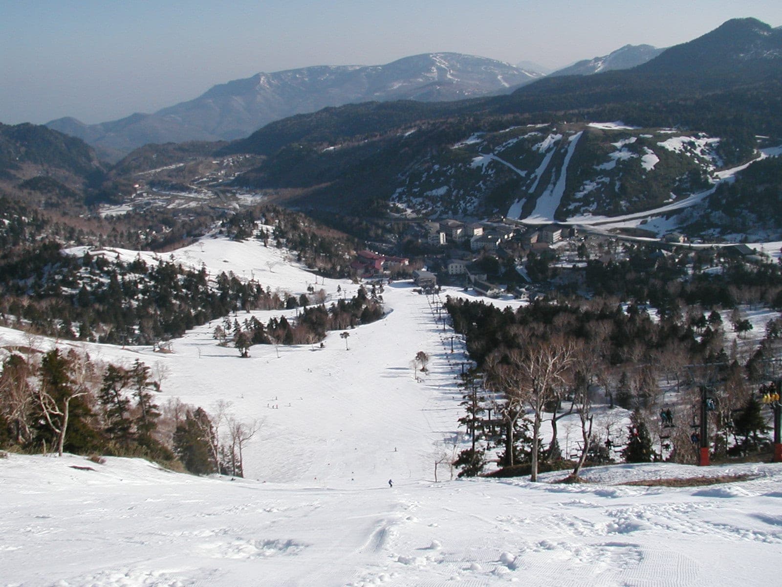 A wide Kumanoyu run still holds deep snow in early May above the Shiga Kogen valley