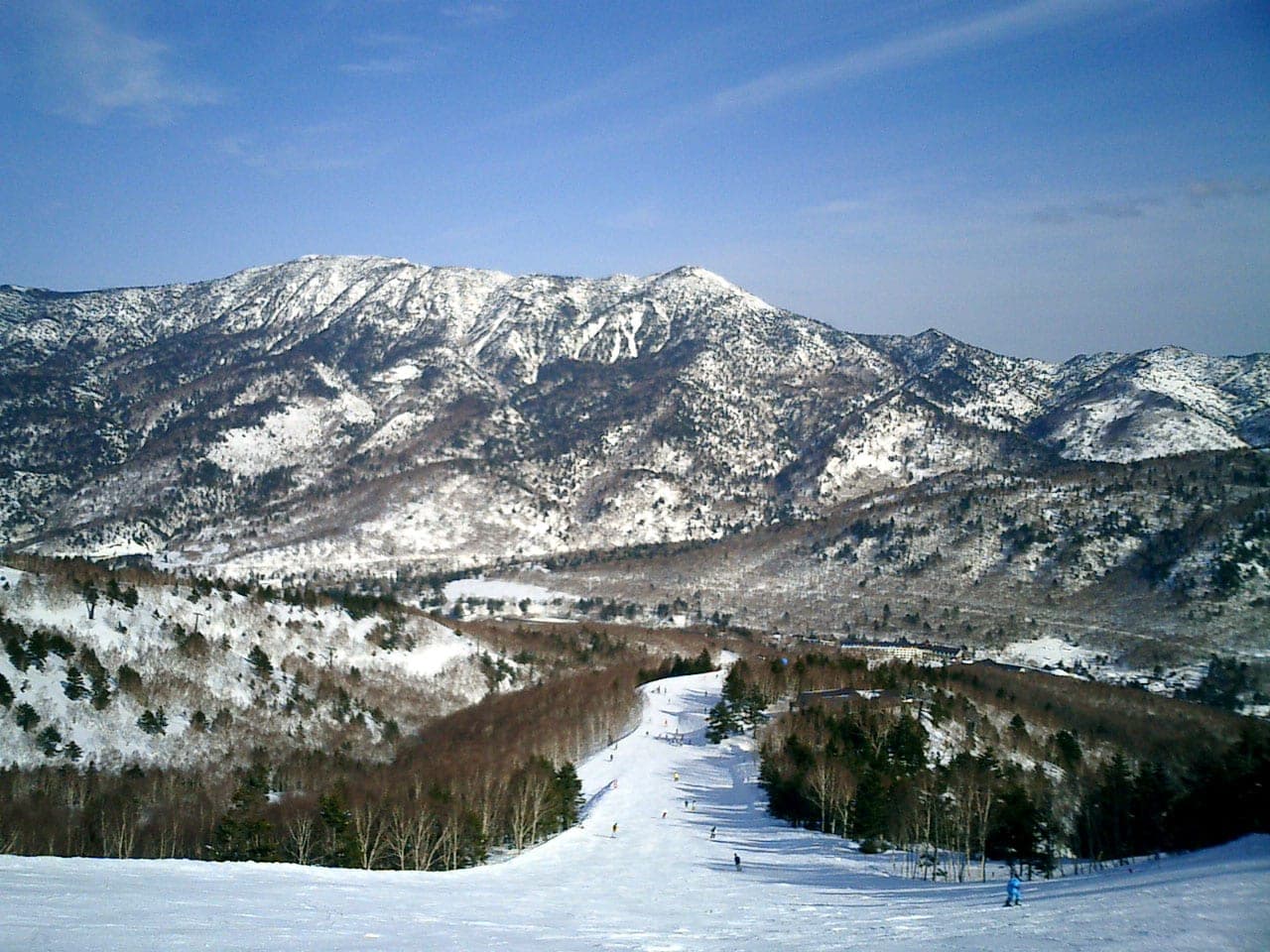 A long run at Okushiga Kogen drops toward the valley below snowy ridges on a clear March day