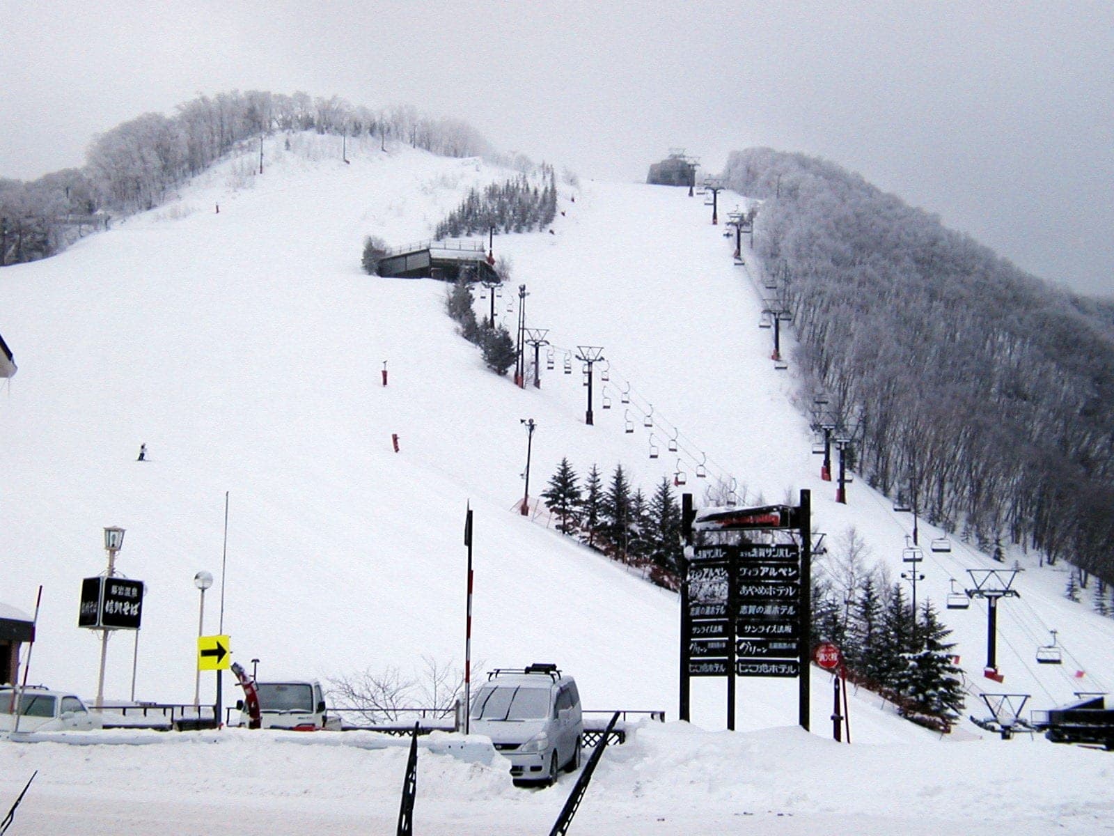 Two chairlifts climb the open slope of Shiga Kogen Sun Valley between frosted trees