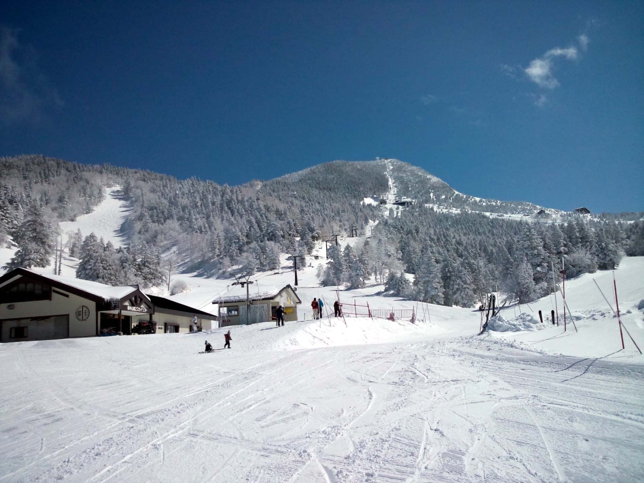 Skiers gather at a base lodge below the rime-white summit of Yokoteyama in Shiga Kogen