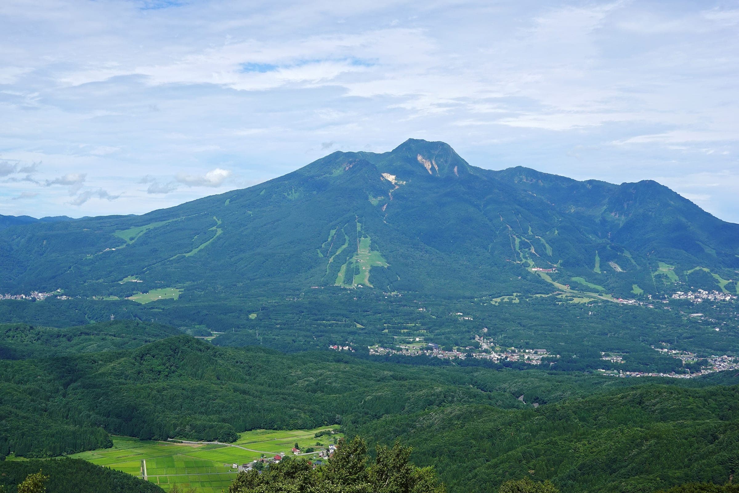 Mount Myoko and its green ski runs rise across the valley from the Nojiriko Terrace at Tangram