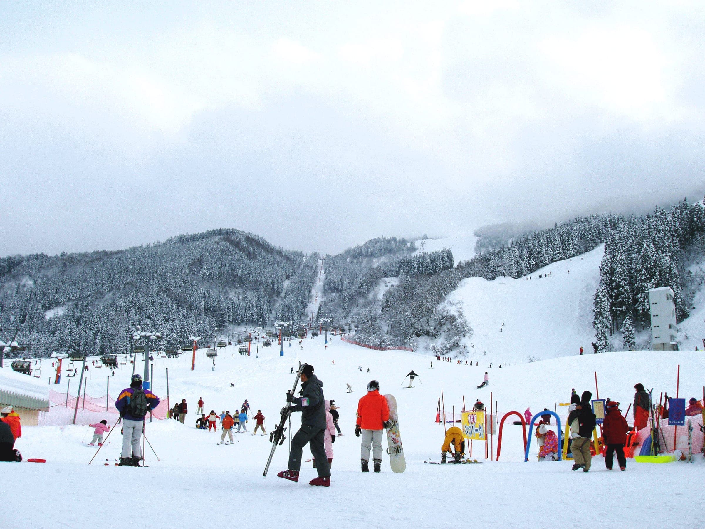 Snowboarders and skiers gather at the base of the Gokurakuzaka area of Tateyama Sanroku Ski Resort