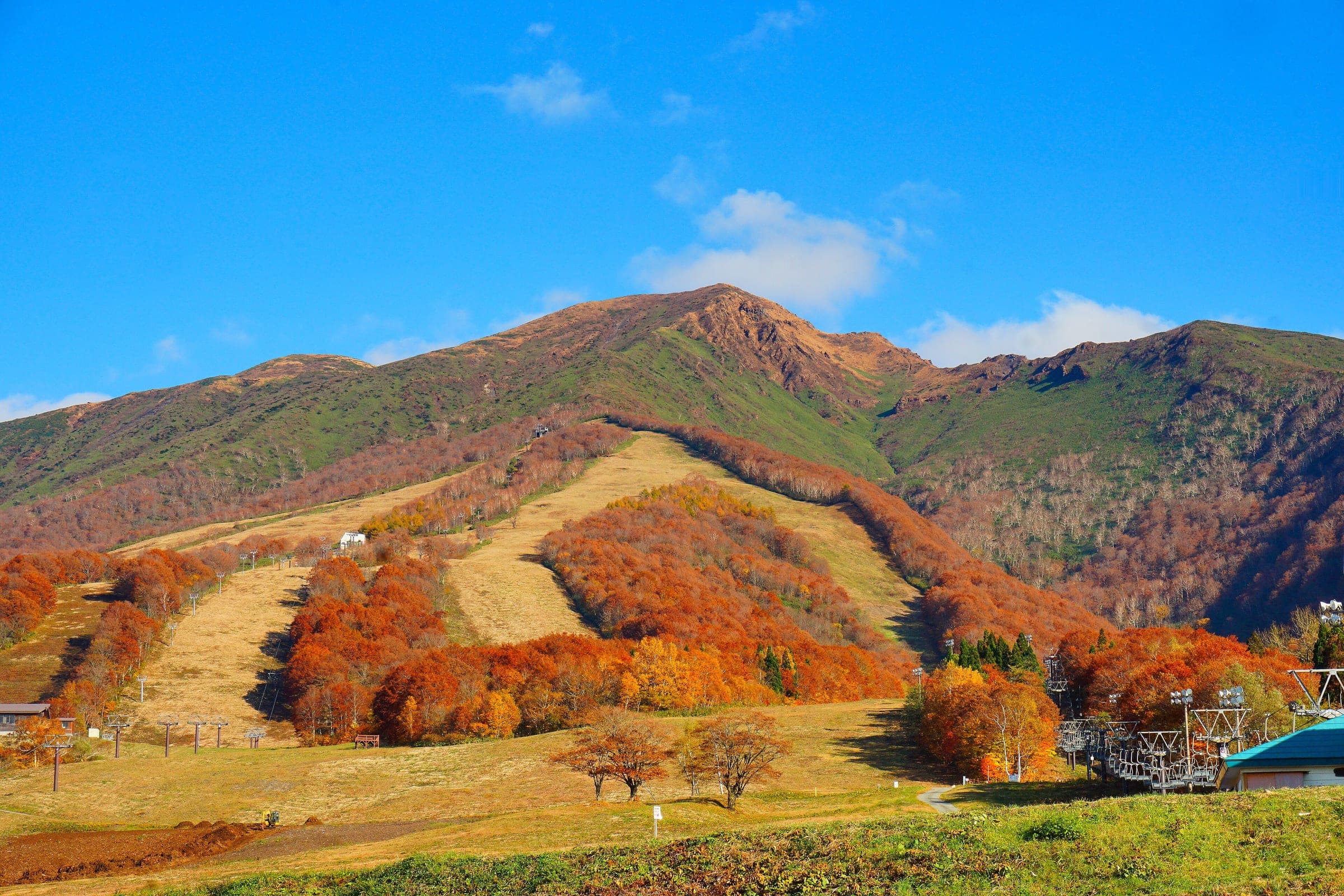 Autumn colour fills the Tazawako ski trails below the summit of Mount Akita-Komagatake.