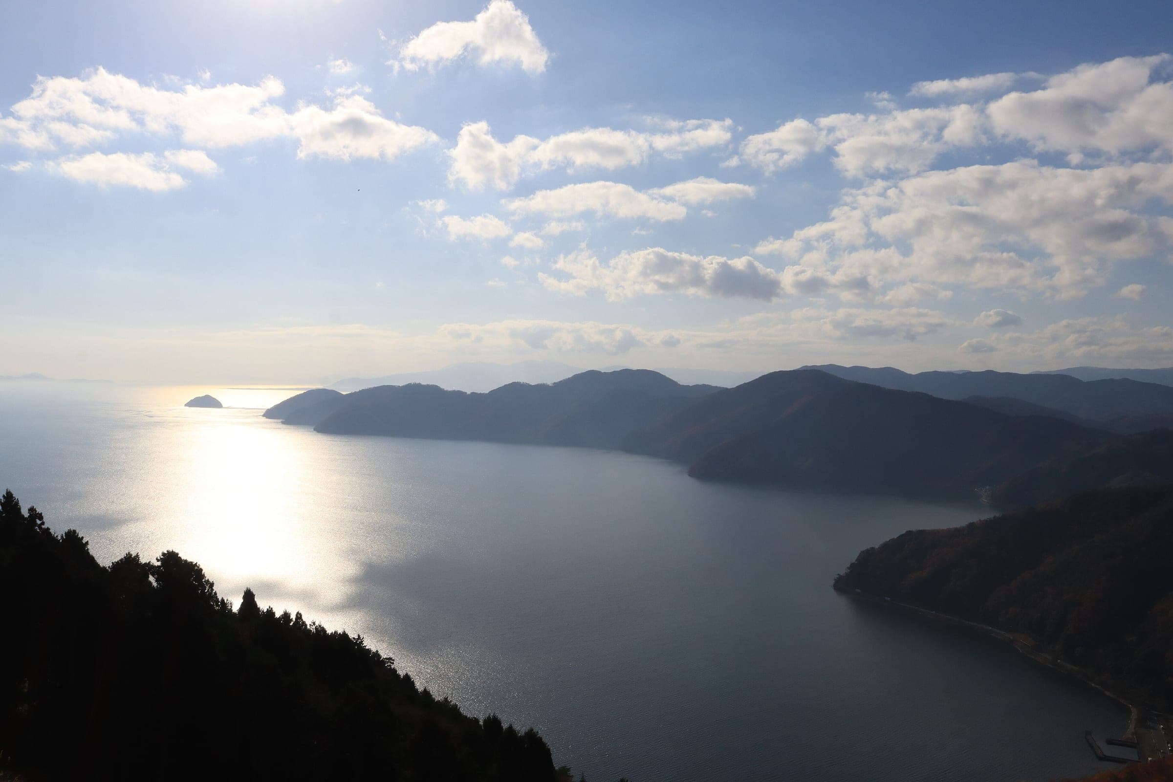 Lake Biwa's northern arm glints below forested headlands in a view from Mount Shizu near Kinomoto